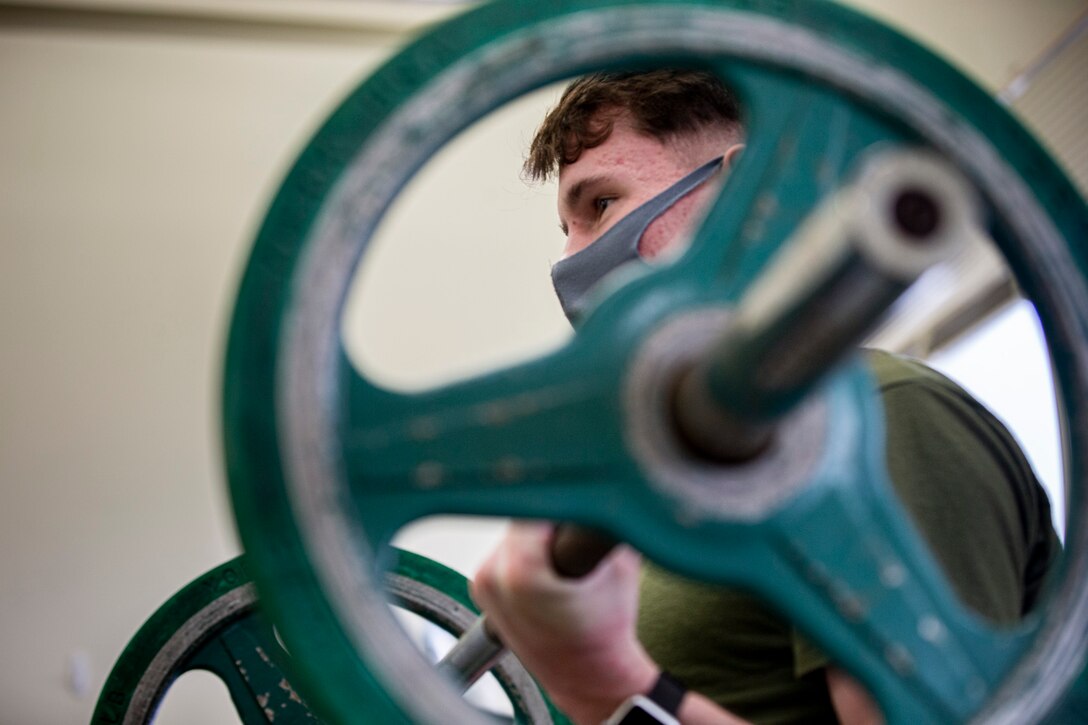 U.S. Marine Corps Lance Cpl. Kamerin Hervey, an administrative law clerk with the Legal Services Support Section, Headquarters and Support Battalion, conducts a bicep curl on Camp Foster, Okinawa, Japan, Feb. 22, 2021. Hervey is a wheelchair bound active duty Marine due to his bilateral tibia stress fractures in both shins. He was injured during the initial Combat Fitness Test at recruit training, but he does not let it hold him back. Every day has its own set of challenges, but through courage and persistence Hervey stays true to himself and others. Hervey is a native of  Longmont, Colorado. (U.S. Marine Corps photo by Cpl. Karis Mattingly)