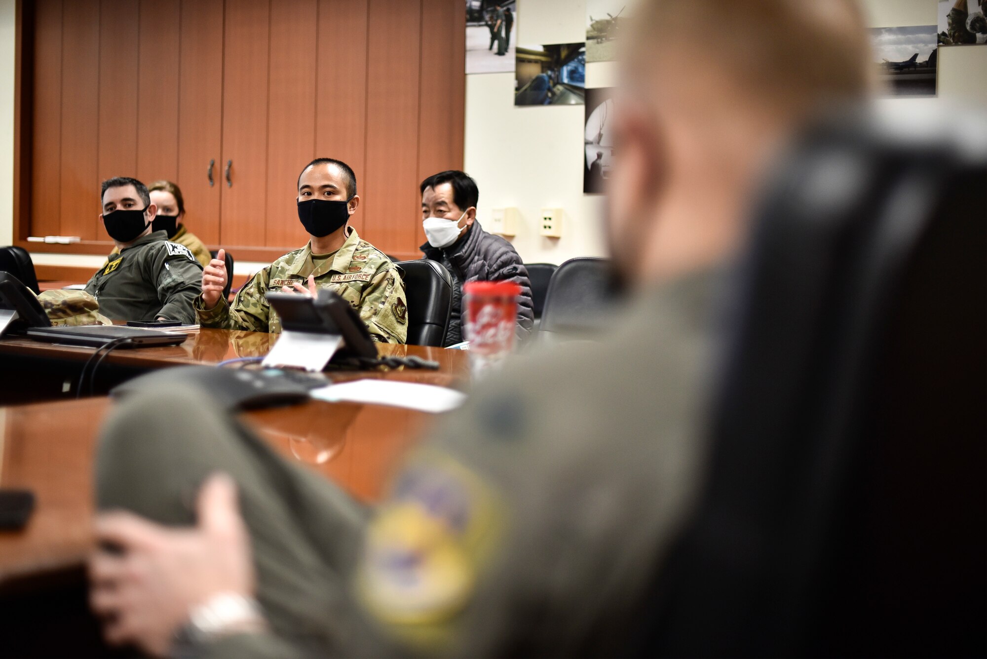 Airmen speak during a briefing.