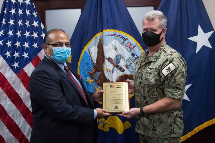 210303-N-IO414-1005 NAVAL SUPPORT ACTIVITY BAHRAIN (March 3, 2021) Vice Adm. Samuel Paparo, right, commander of U.S. Naval Forces Central Command (NAVCENT), U.S. 5th Fleet and Combined Maritime Forces, presents a plaque to his Excellency Piyush Srivastava, Ambassador of India to the Kingdom of Bahrain, during a tour of the NAVCENT headquarters onboard Naval Support Activity Bahrain, March 3. NAVCENT is the U.S. Navy element of U.S. Central Command in the U.S. 5th Fleet area of operations, which encompasses about 2.5 million square miles of water area and includes the Arabian Gulf, Gulf of Oman, Red Sea and parts of the Indian Ocean. The expanse is comprised of 20 countries and includes three critical choke points at the Strait of Hormuz, the Suez Canal and the Strait of Bab al Mandeb at the southern tip of Yemen. (U.S. Navy photo by Mass Communication Specialist 2nd Class Jordan Crouch)