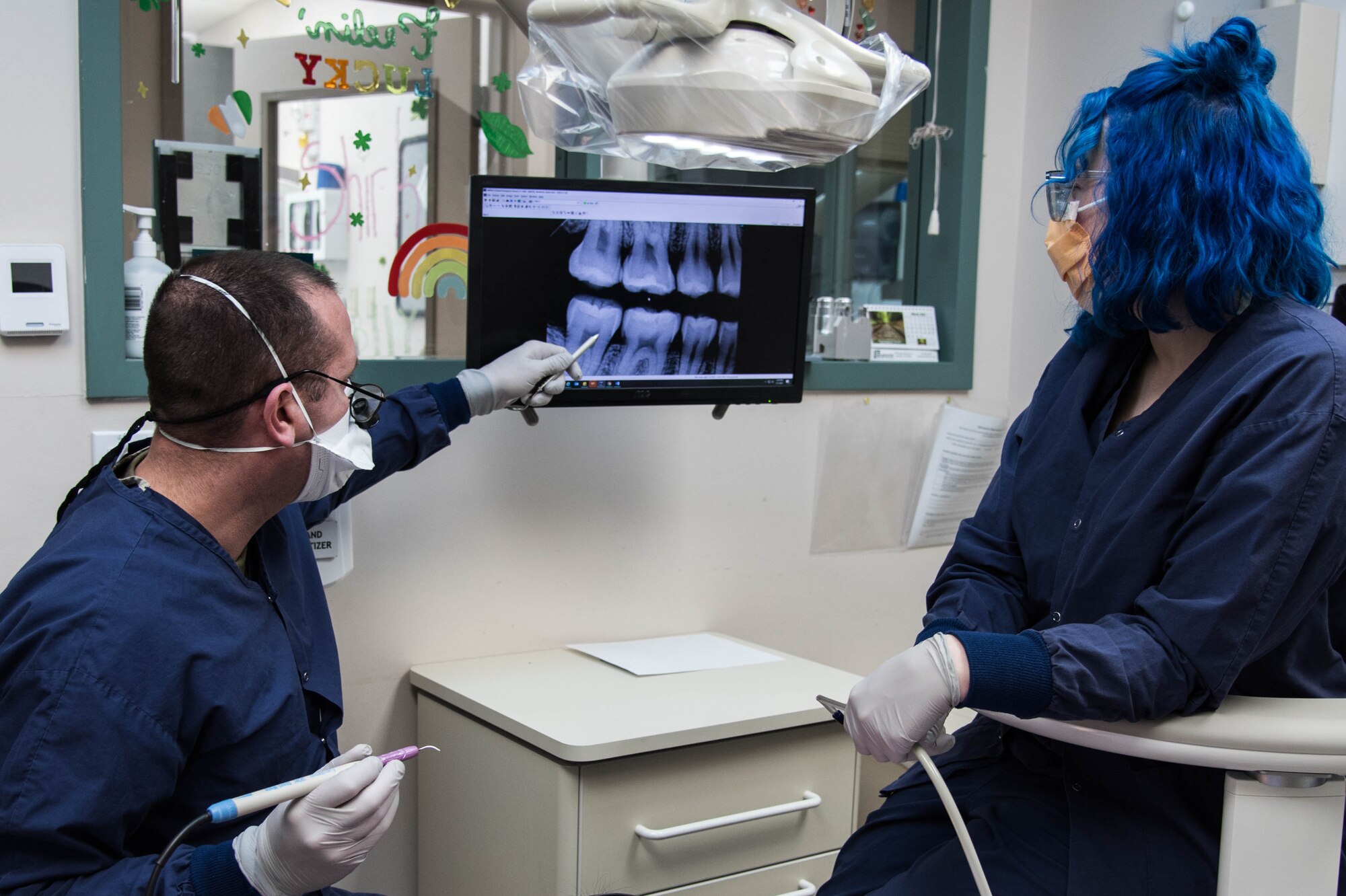 Maj. James Koll, 22nd Operational Medical Readiness Squadron dental flight commander, and Chelsea Slagle, 22 OMRS dental assistant, observe x-rays during a dental cleaning March 1, 2021, at McConnell Air Force Base, Kansas. March 6 is observed as National Dentist Day, celebrating the hard work and dedication of dentists across the world. (U.S. Air Force photo by Senior Airman Alexi Bosarge)