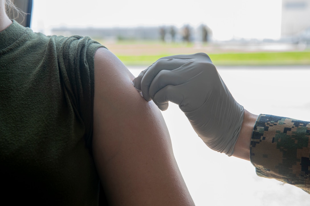 A U.S. Marine gets her arm disinfected to receive her second dose of the COVID-19 vaccine at the U.S. Naval Hospital Okinawa, on Camp Foster, Mar. 2.