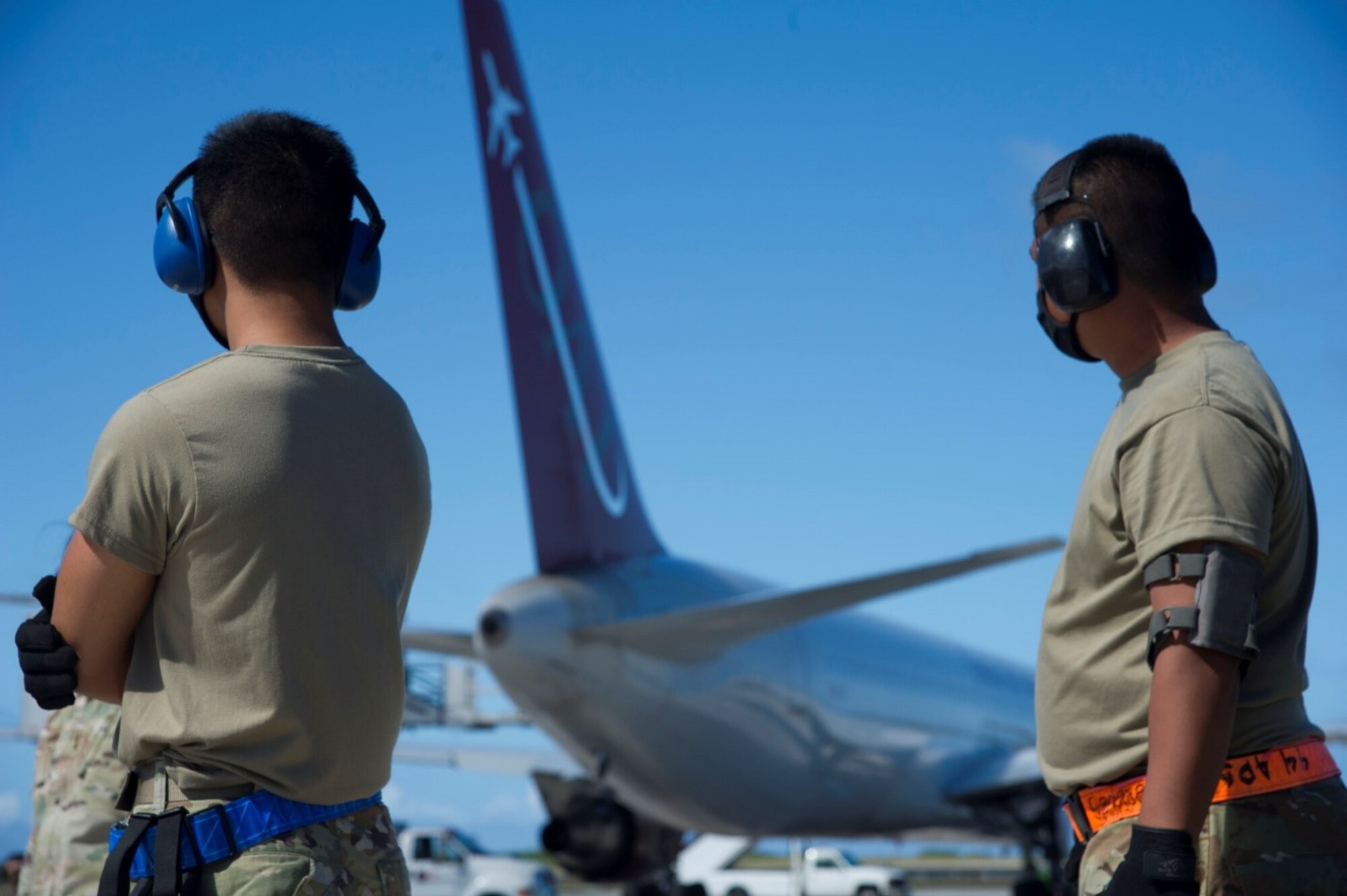 U.S. Air Force Airman Lynch Santos, left, and Tech. Sgt. Bedrick Briones, both 44th Aerial Port Squadron air transportation specialists, wait on the flight line for the final blocking of the Omni Air International aircraft carrying the COVID-19 refrigerators bound for Andersen Air Force Base, Guam, Feb. 23, 2021.