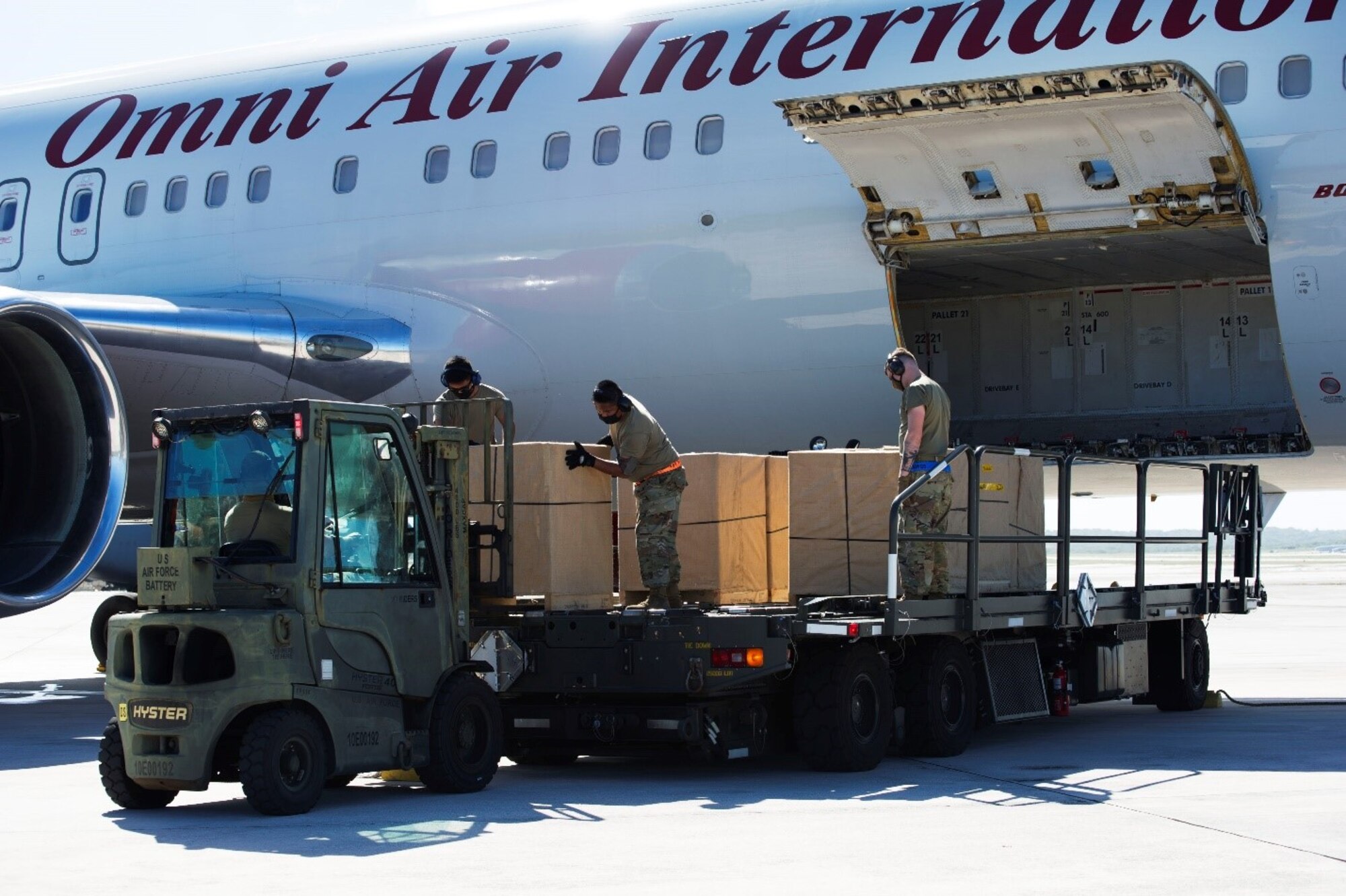 An Omni Air International aircraft is unloaded by air transportation freight specialists from the 44th Aerial Port Squadron and the 734th Air Mobility Squadron at Andersen Air Force Base, Guam, Feb. 23, 2021.