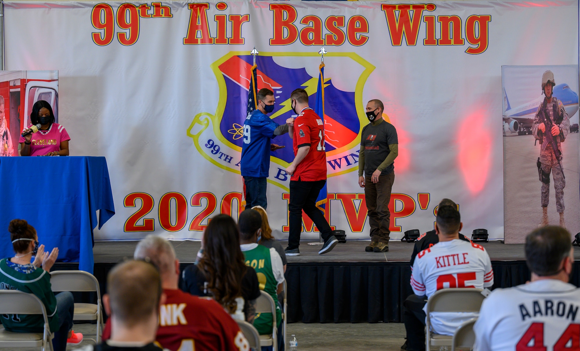 Airmen greet another Airman on stage.