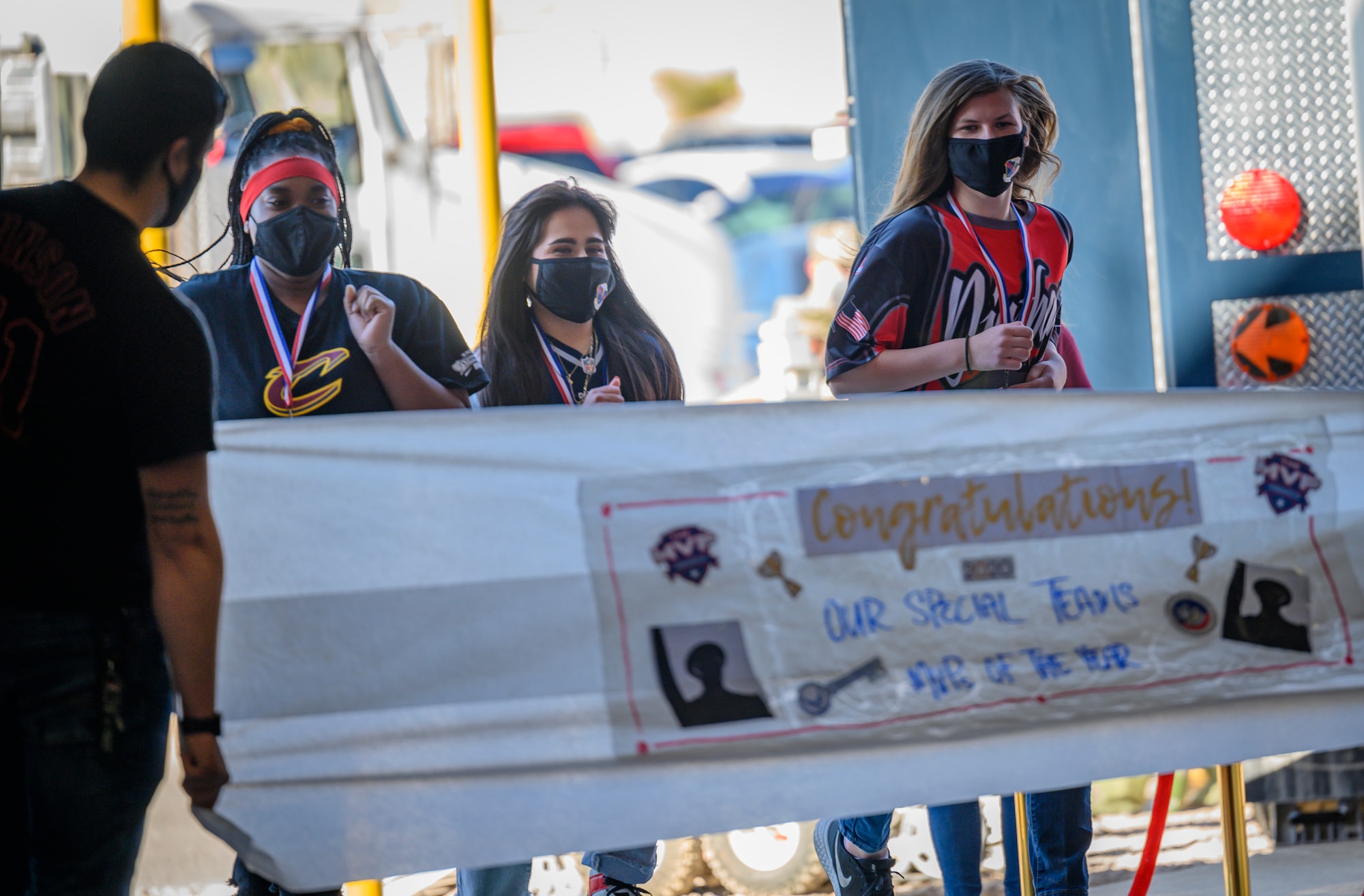 Airmen run through a banner.