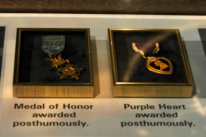 A Medal of Honor and a Purple Heart medal are in separate cases, side-by-side in a display.