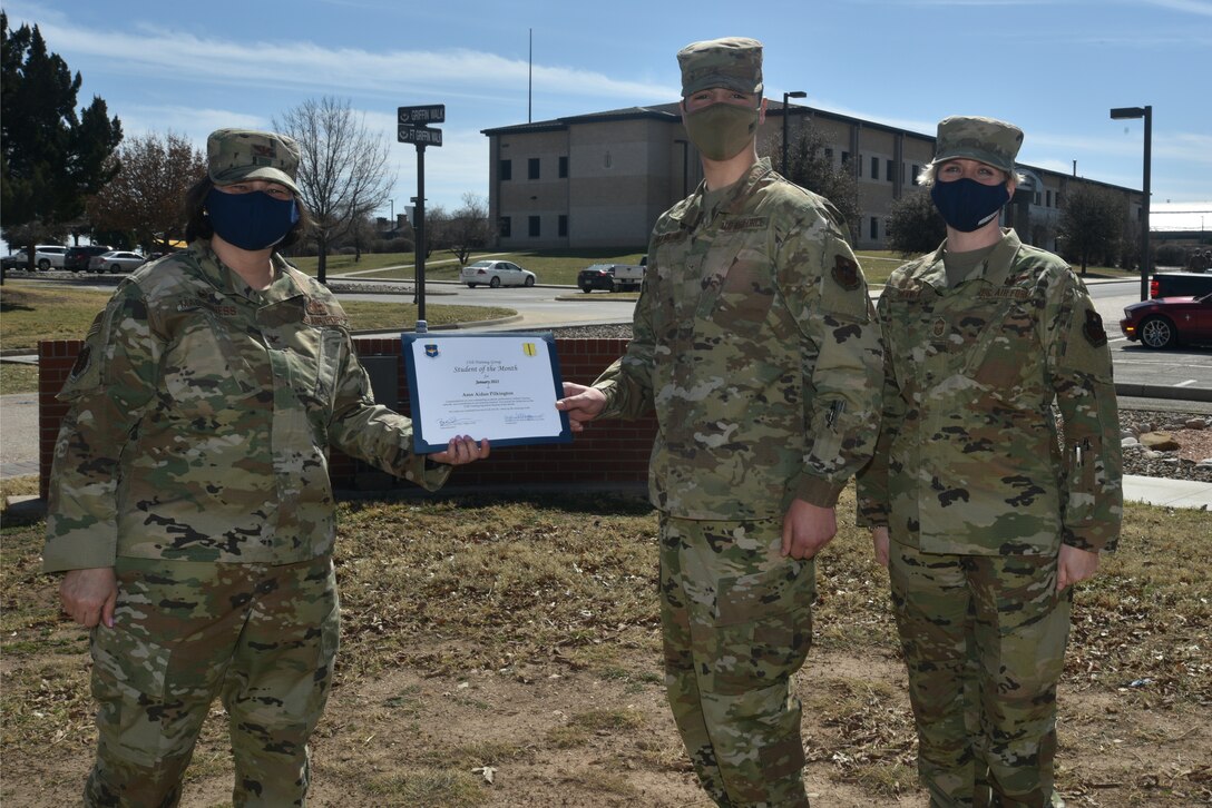 U.S. Air Force Col. Angelina Maguinness, 17th Training Group commander, presents Airman Aidan Pilkington, 312th Training Squadron student, the 17th TRG Student of the Month award outside of Brandenburg Hall on Goodfellow Air Force Base, Texas, Feb. 26, 2021. Pilkington worked hard for his award and has shown dedication to his squadron and the training he received at Goodfellow. (U.S. Air Force photo by Senior Airman Ashley Thrash)