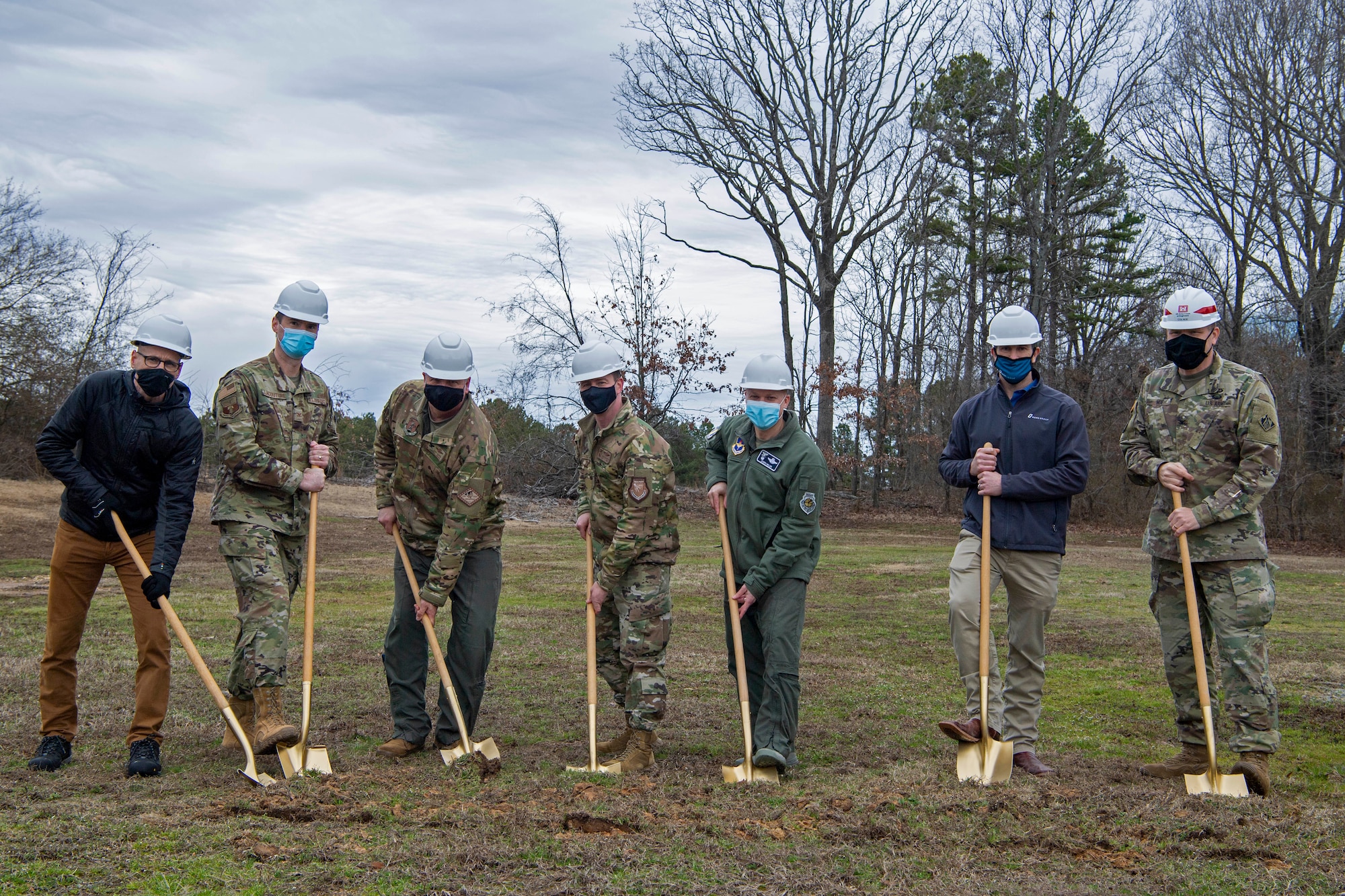 7 individuals prepare to break ground during a ceremony.