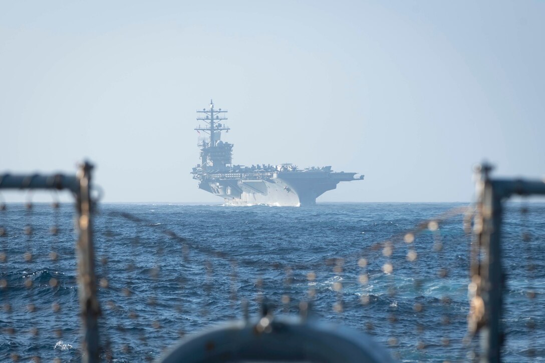 A ship is seen sailing from the back of another.