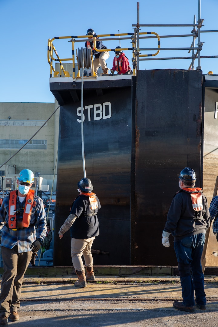 Code 992 prepare to remove the caisson from Dry Dock 8 for the arrival of a U.S. Navy vessel.
