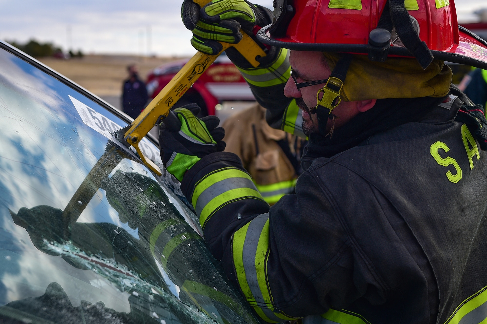 Fire Lt. Chris Gay, the training cordinator for the Sable Altura Fire Rescue, saws into the windshield of a car during an auto extraction exercise on Buckley Air Force Base, Colo., Feb. 24, 2021.