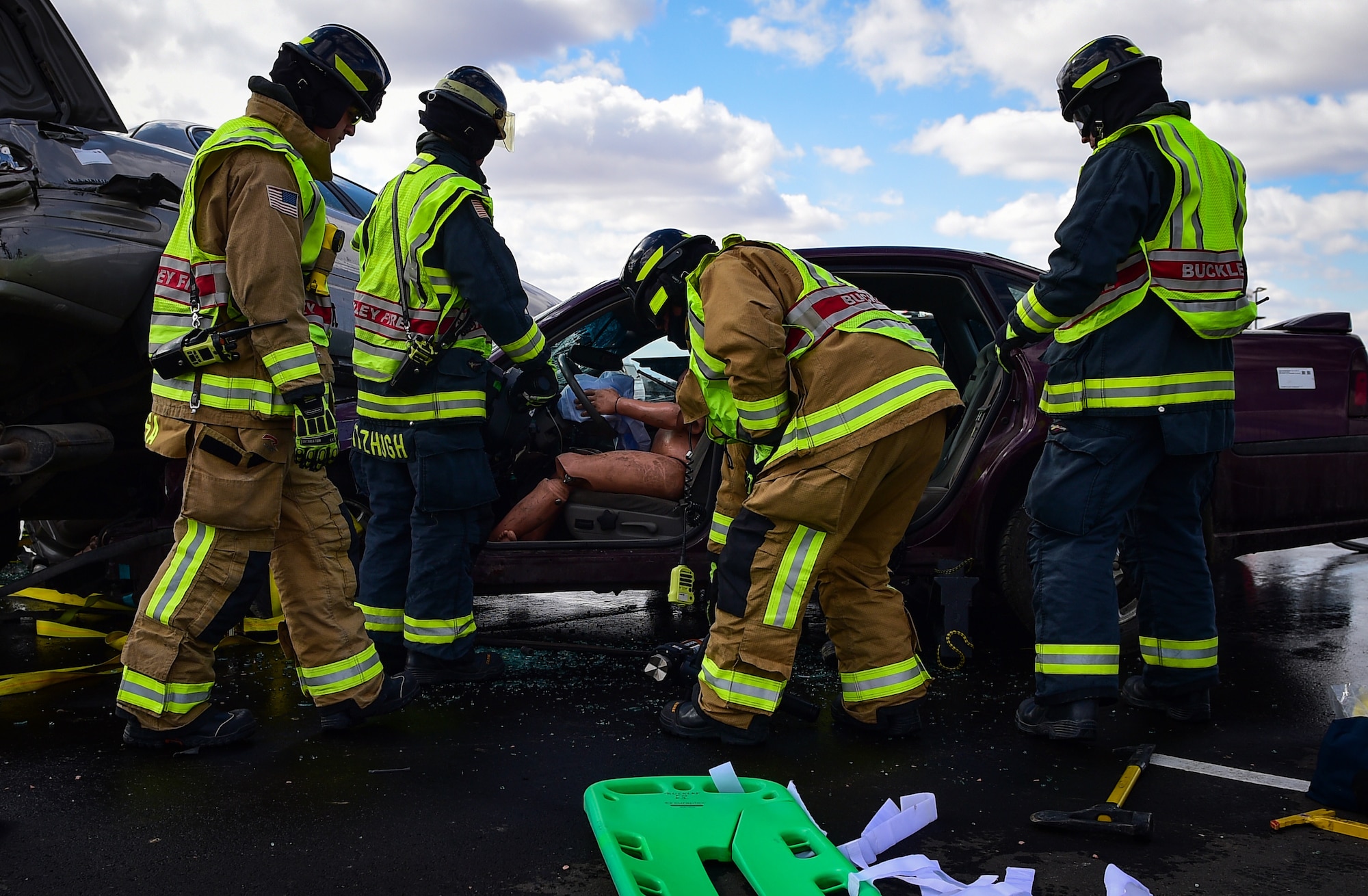 Four firefighters from the 460th Civil Engineer Squadron practice saving a rescue mannequin from a simulated major vehicle accident during an auto extraction exercise on Buckley Air Force Base, Colo., Feb. 24, 2021.