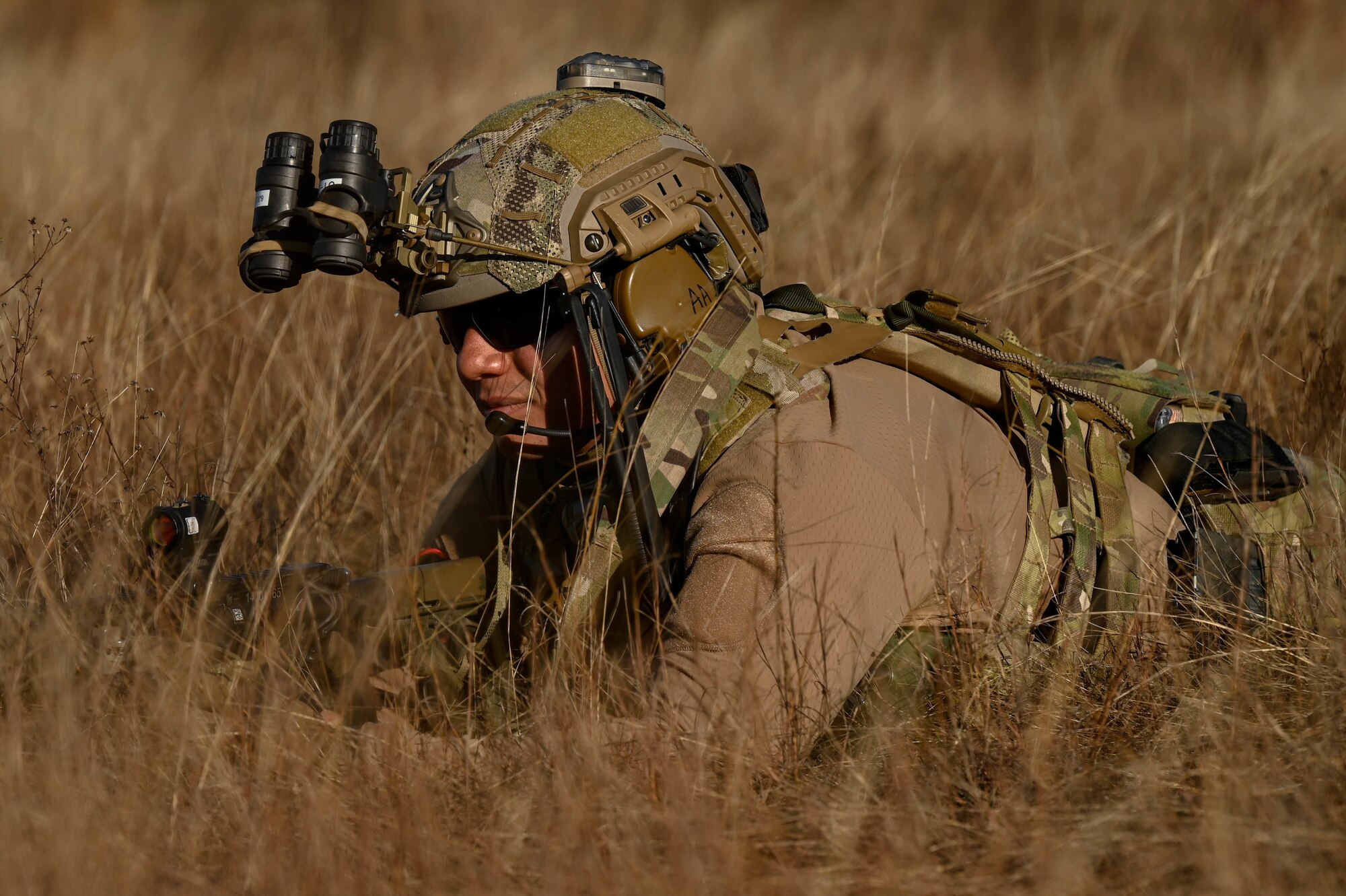 A U.S. Air Force Special Tactics operator lays in the grass to pull security while his team sets up an airfield at Eglin Range, Florida, during Emerald Warrior 21.1, Feb. 19, 2021. Special Tactics teams conduct airfield seizure and control operations to ensure uncontested access for joint forces. Emerald Warrior is the largest joint special operations exercise involving U.S. Special Operations Command forces training to respond to various threats across the spectrum of conflict. (U.S. Air Force photo by Tech. Sgt. Rose Gudex)