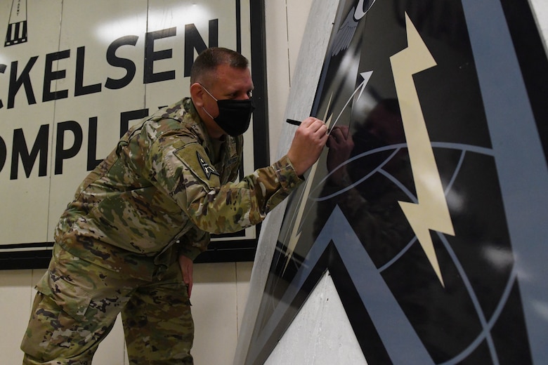 U.S. Space Force Col. Richard Bourquin, Space Delta 4 commander, signs his name on a DEL 4 emblem at Cavalier Air Force Station, N.D., Feb. 22, 2021. The 10th Space Warning Squadron has a tradition of immortalizing all the members that visit or work at the station. (U.S. Space Force photo by Airman 1st Class Andrew Garavito)