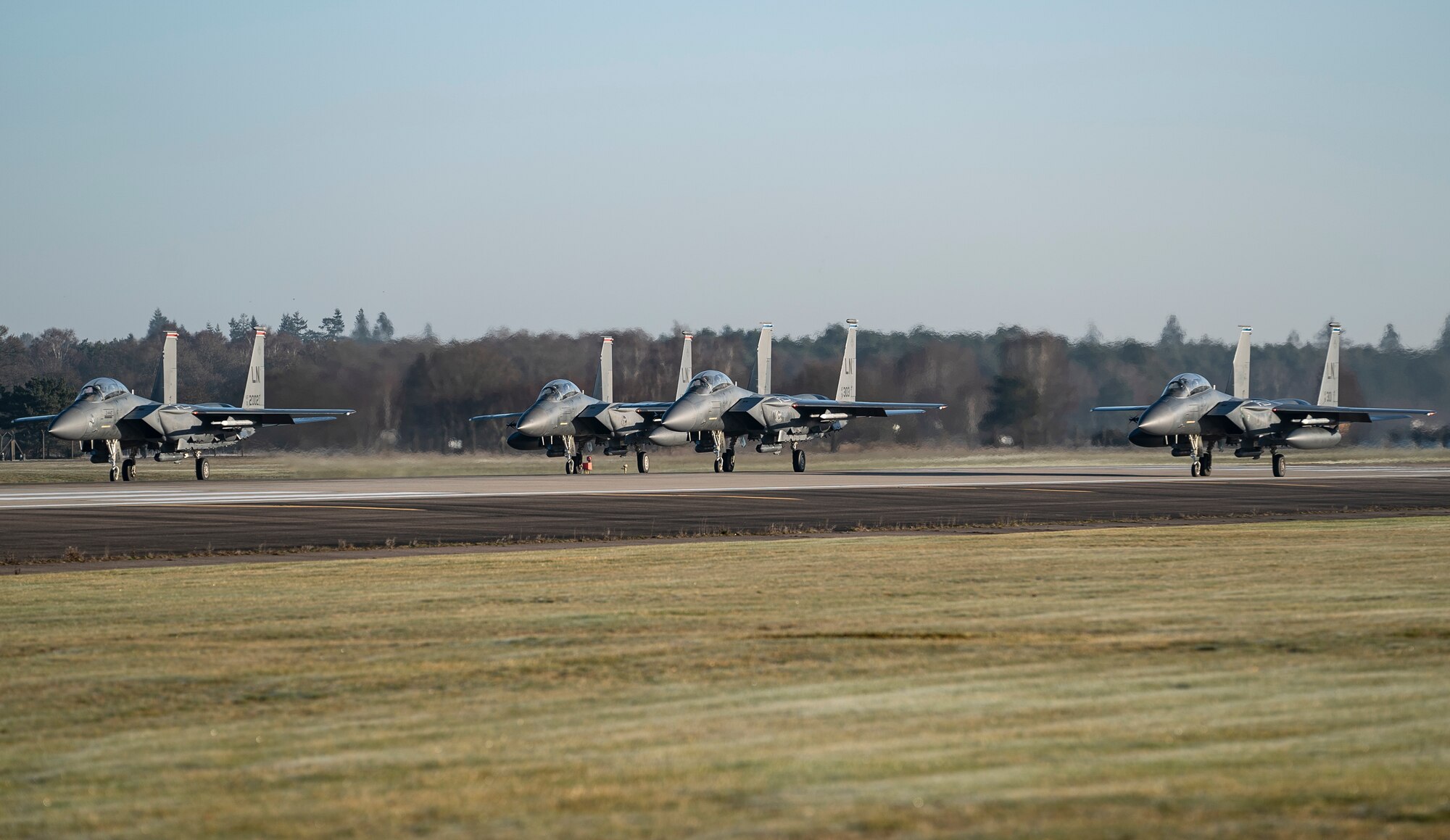 F-15E Strike Eagles line up on the runway for the first wave of orientation flight take-offs at Royal Air Force Lakenheath, England, Feb. 26, 2021. Orientation flights are offered to those who have responsibilities related to aviation and aircraft or as an award to individuals who show exceptional performance in their duties. (U.S. Air Force photo by Airman 1st Class Jessi Monte)