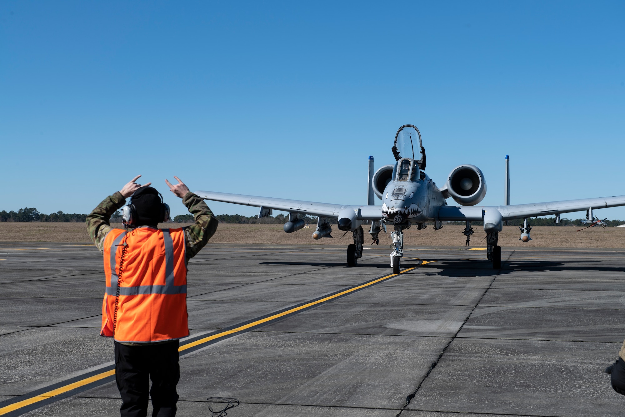 A photo of an Airman standing in front of and A-10C Thunderbolt II.