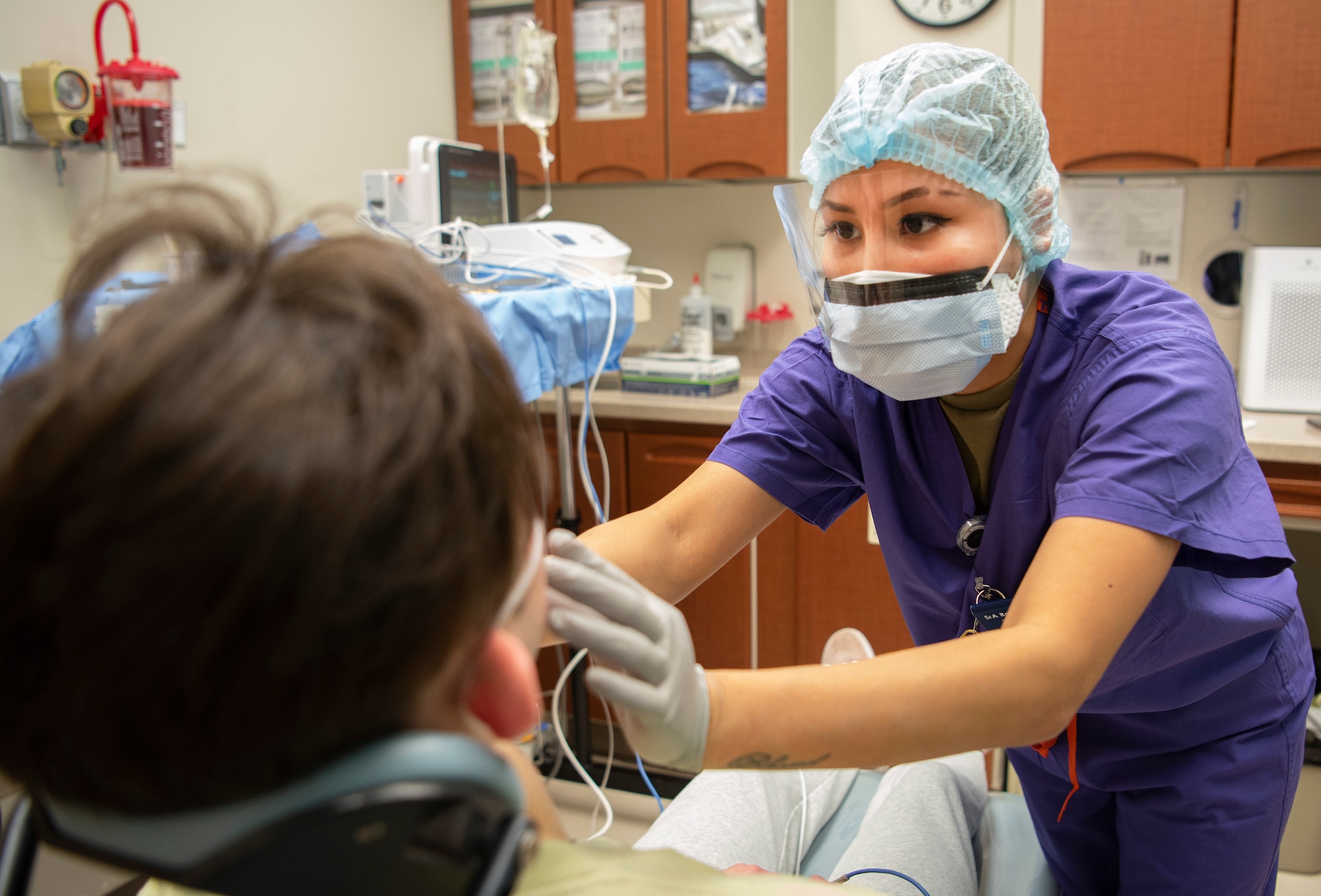 U.S. Air Force Senior Airman Ranie Siscar, 88th Dental Squadron dental assistant, checks on a patient following oral surgery Feb. 22, 2021, in the dental clinic at Wright-Patterson Air Force Base, Ohio. The Wright-Patt clinic observed Dental Assistants Recognition Week the first week of March. (U.S. Air Force photo by R.J. Oriez)