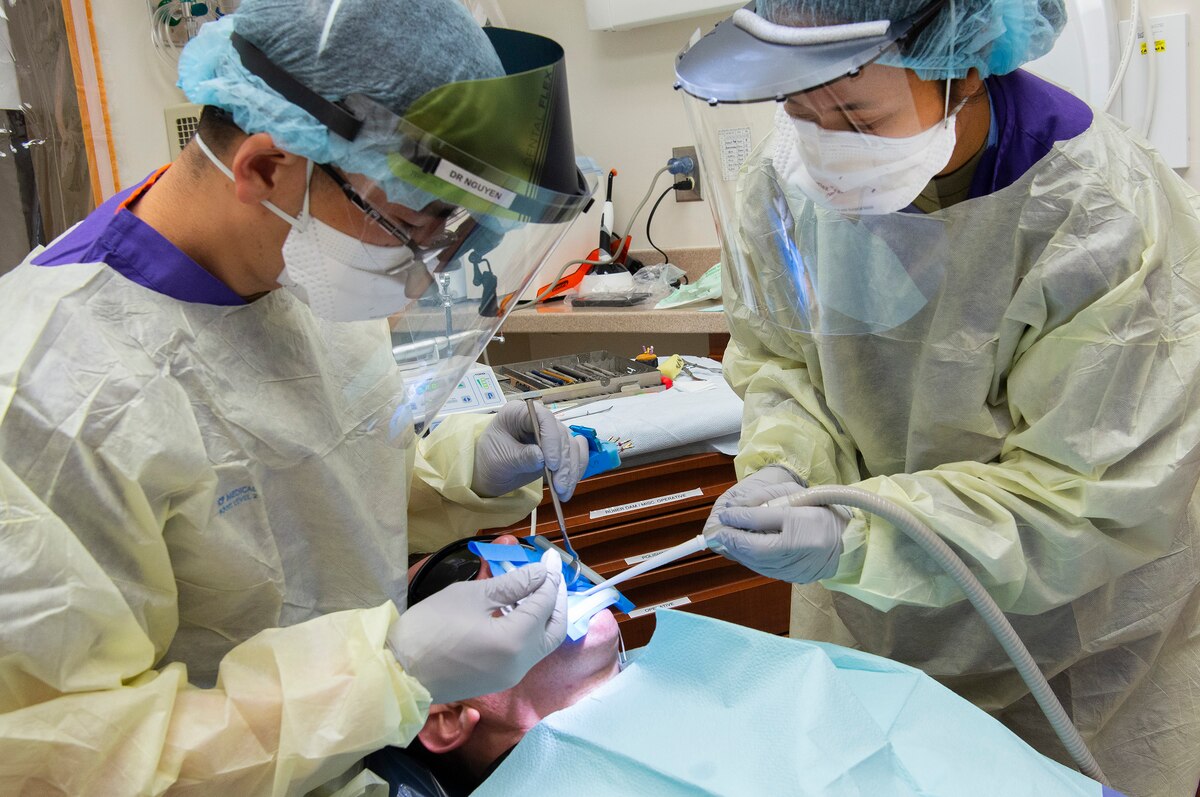 U.S. Air Force Airman 1st Class Gaudley Peji, right, 88th Dental Squadron dental assistant, works with Capt. Daniel Nguyen, 88 DS dental resident, during a procedure in the dental clinic at Wright-Patterson Air Force Base, Ohio,  Feb. 22, 2021. The Wright-Patt clinic observed Dental Assistants Recognition Week the first week of March. (U.S. Air Force photo by R.J. Oriez)
