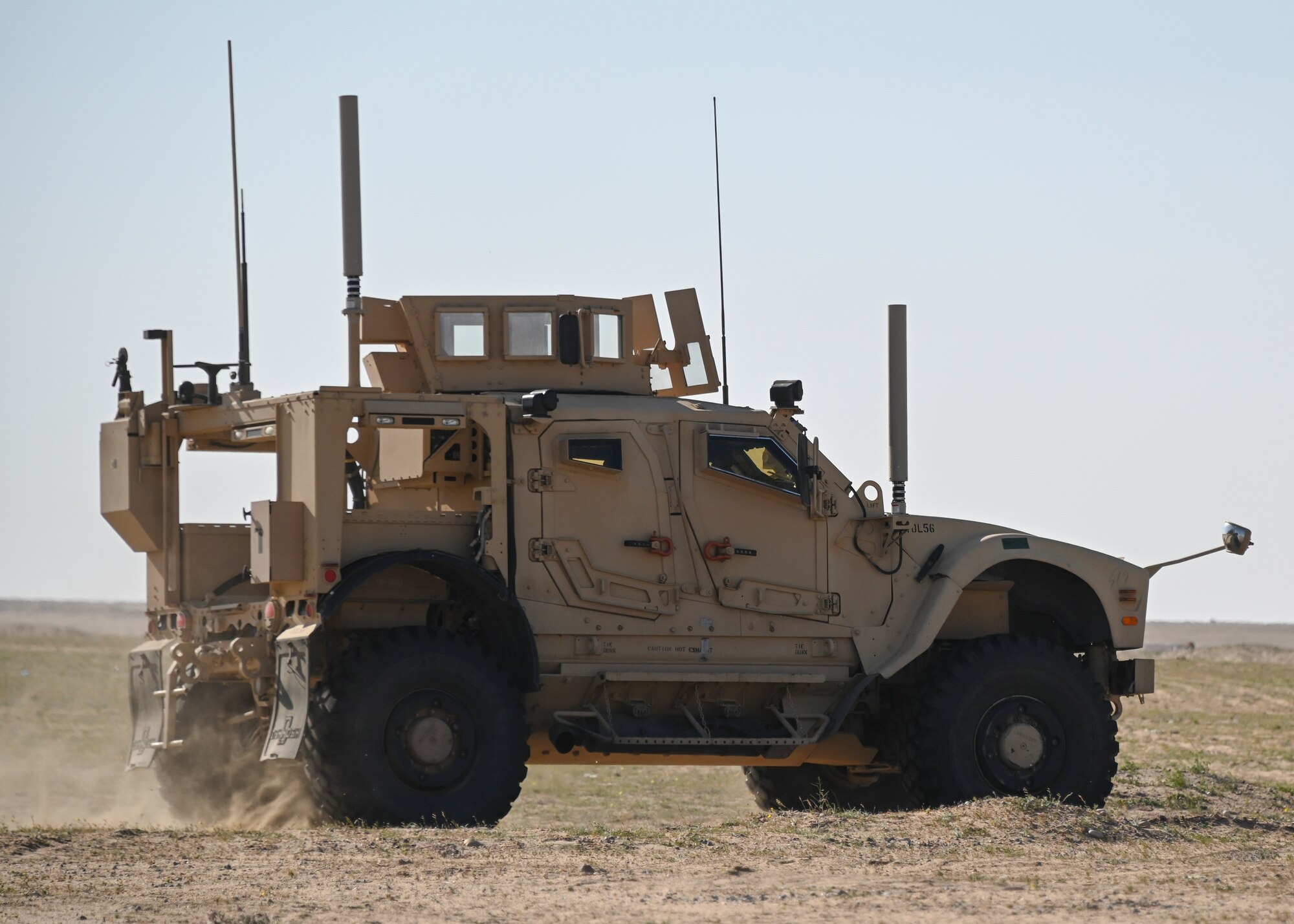 A photo of a Humvee driving in the desert