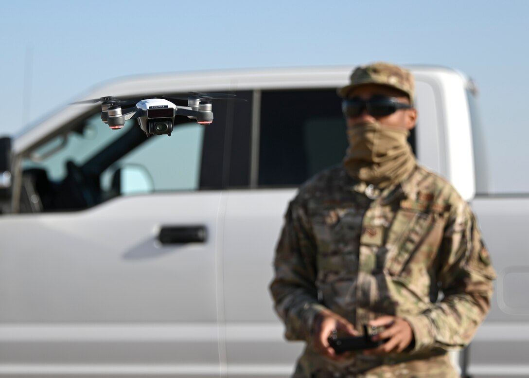 A photo of an Airman flying a drone