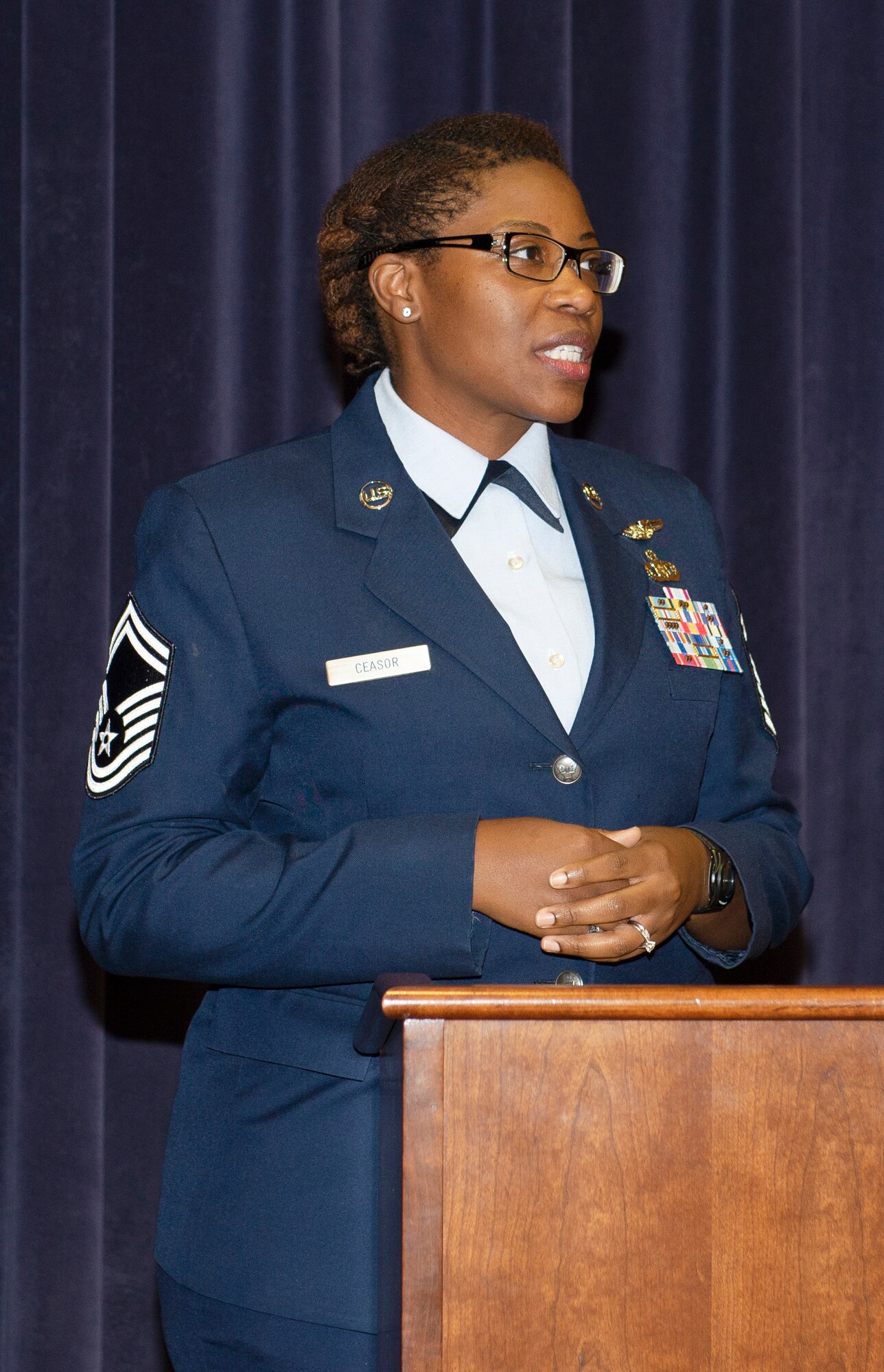 female Air Force Senior Master Sergeant standing behind a podium speaking