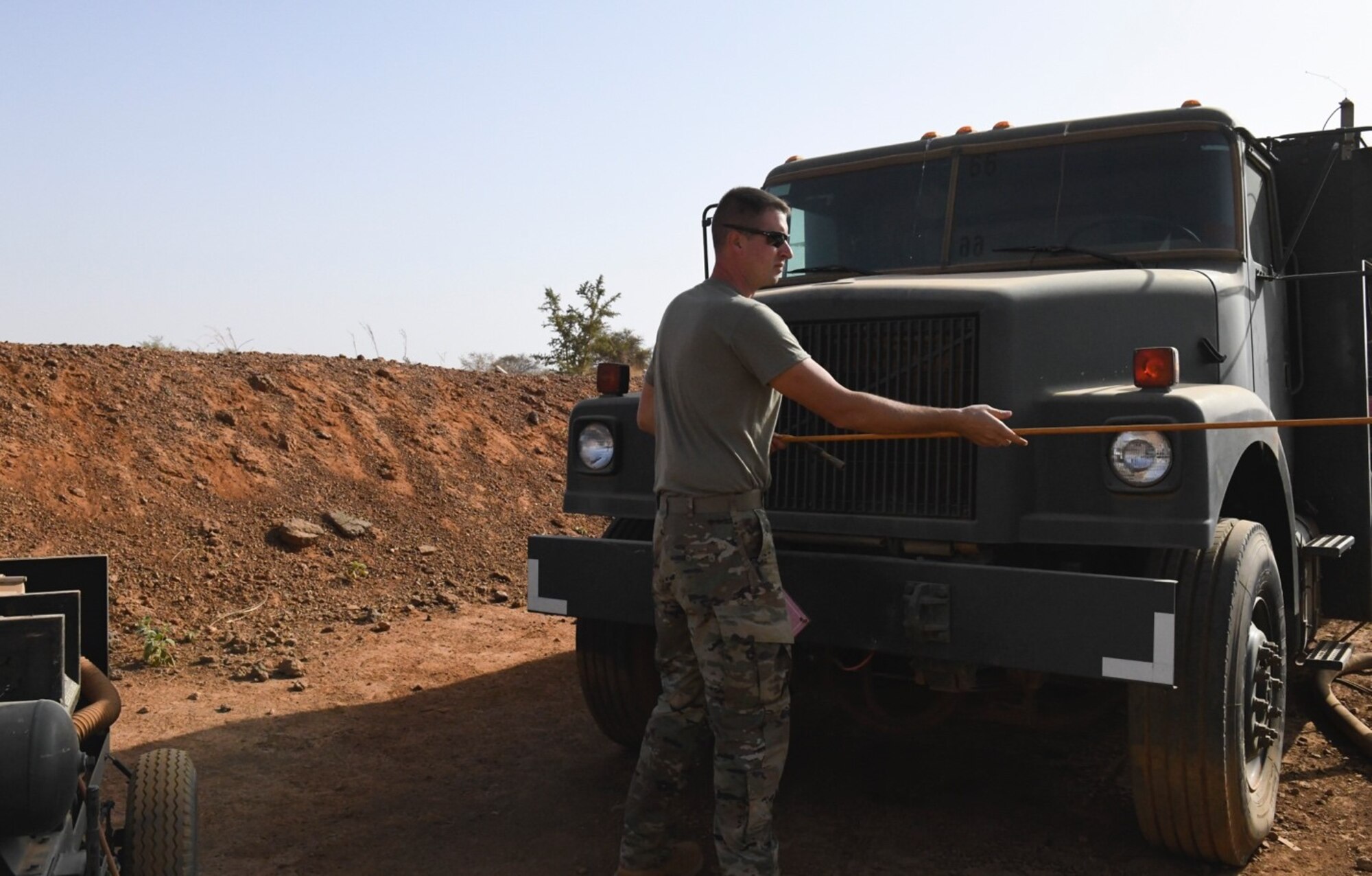U.S. Air Force Staff Sgt. Mathew Stahl, 768th Expeditionary Air Base Squadron fuels management section chief, pulls the hose of an air pump to connect it to an R-11 fuels truck air compressor at Nigerien Air Base 101, Niamey, Niger, Feb. 15, 2021. As the fuels flight chief, part of Stahl’s job duties are to order, receive and accept all the Jet-A 1 fuel for U.S. missions. (U.S. Air Force photo by Senior Airman Gabrielle Winn)