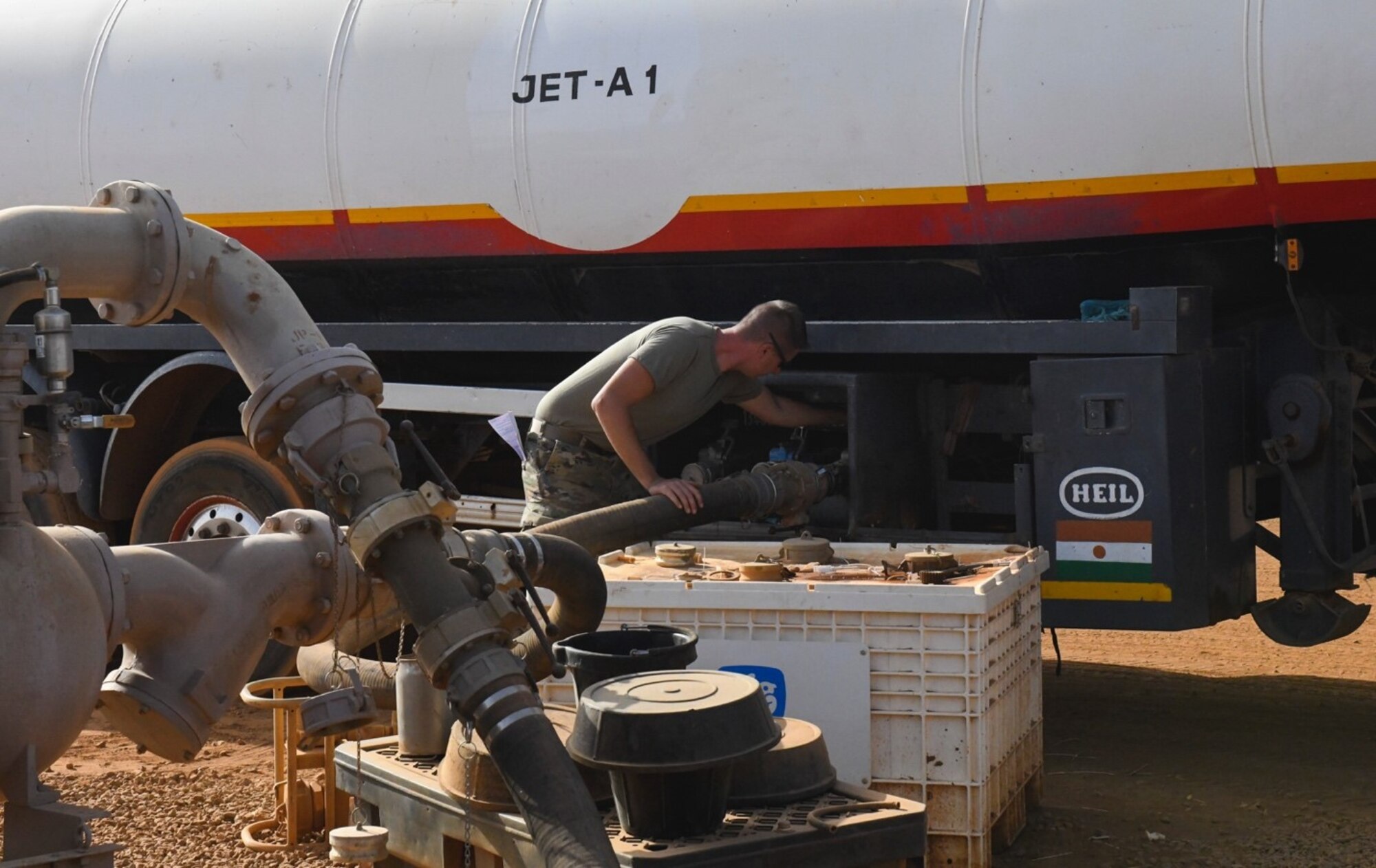 U.S. Air Force Staff Sgt. Mathew Stahl, 768th Expeditionary Air Base Squadron fuels management section chief, connects a fuel receipt hose to the opening valve of a Jet-A 1 fuel truck to offload fuel at Nigerien Air Base 101, Niamey, Niger, Feb. 15, 2021. The petroleum, oils and lubrication section is responsible for fueling all U.S. military vehicles and aircraft at Air Base 101. (U.S. Air force photo by Senior Airman Gabrielle Winn)