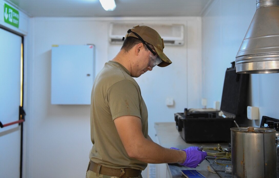 U.S. Air Force Staff Sgt. Justin Sabala, 768th Expeditionary Air Base Squadron fuels laboratory/logistics readiness flight noncommissioned officer in charge, test samples of jet fuel at Nigerien Air Base 101, Niamey, Niger, Feb. 15, 2021. Testing jet fuel quality is important because it ensures that the fuel received is free of any contaminants. (U.S. Air Force photo by Senior Airman Gabrielle Winn)