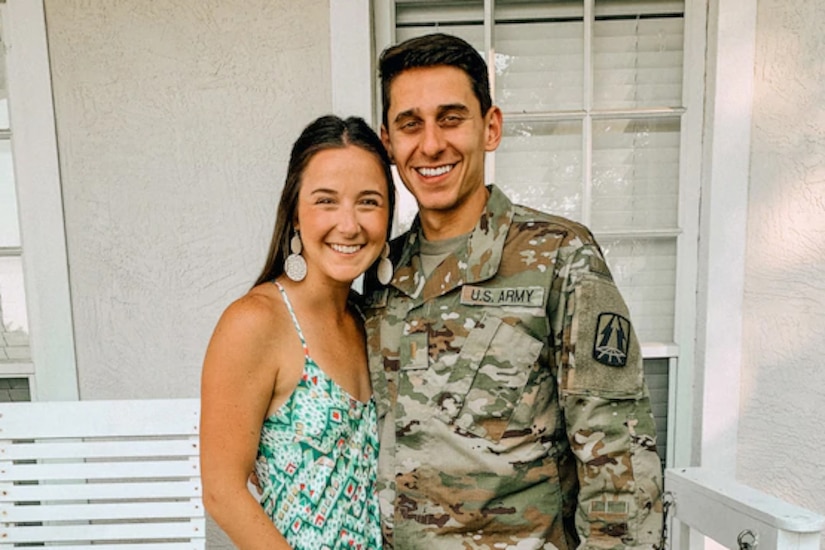 A man in military uniform poses for a photo with a woman.