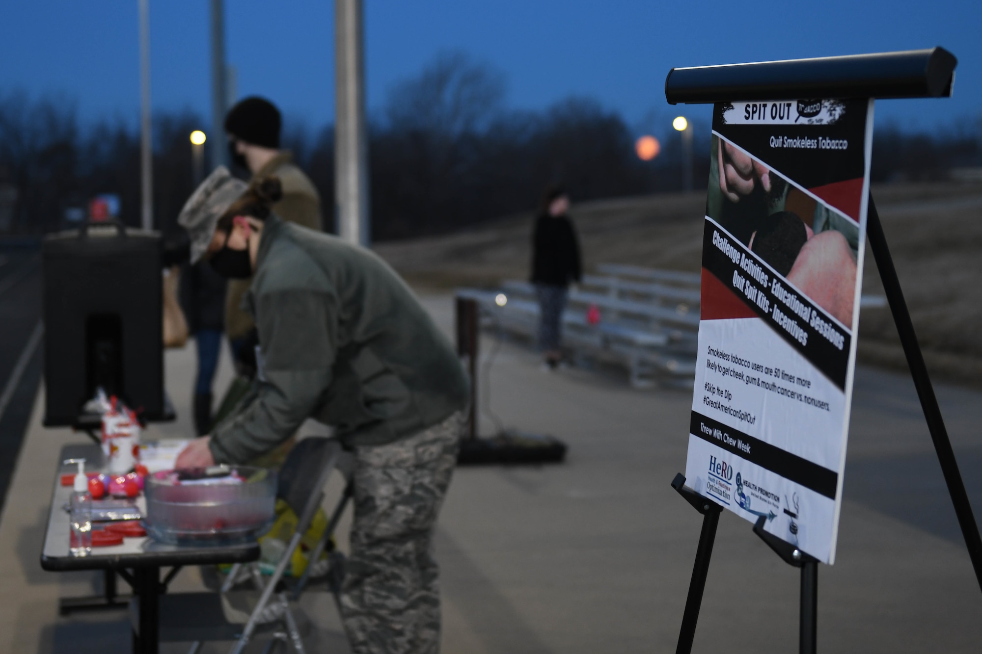 Airman 1st Class Shyenne Burden stands by a table prepares prizes for 5k participants.