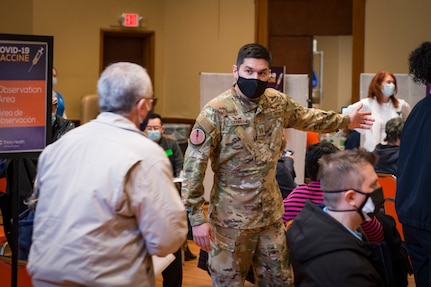 U.S. Air Force Capt. Aaron Sarwar, 118th Airlift Squadron navigator and site lead for Air National Guard personnel, directs patients to stations at a COVID-19 vaccination site at Saint Francis Hospital, Hartford, Connecticut, March 4, 2021. A team of 11 Connecticut Air National Guardsmen provided non-medical administrative support at the site, which was set up to vaccinate 1,500 teachers and staff from Hartford Public Schools.