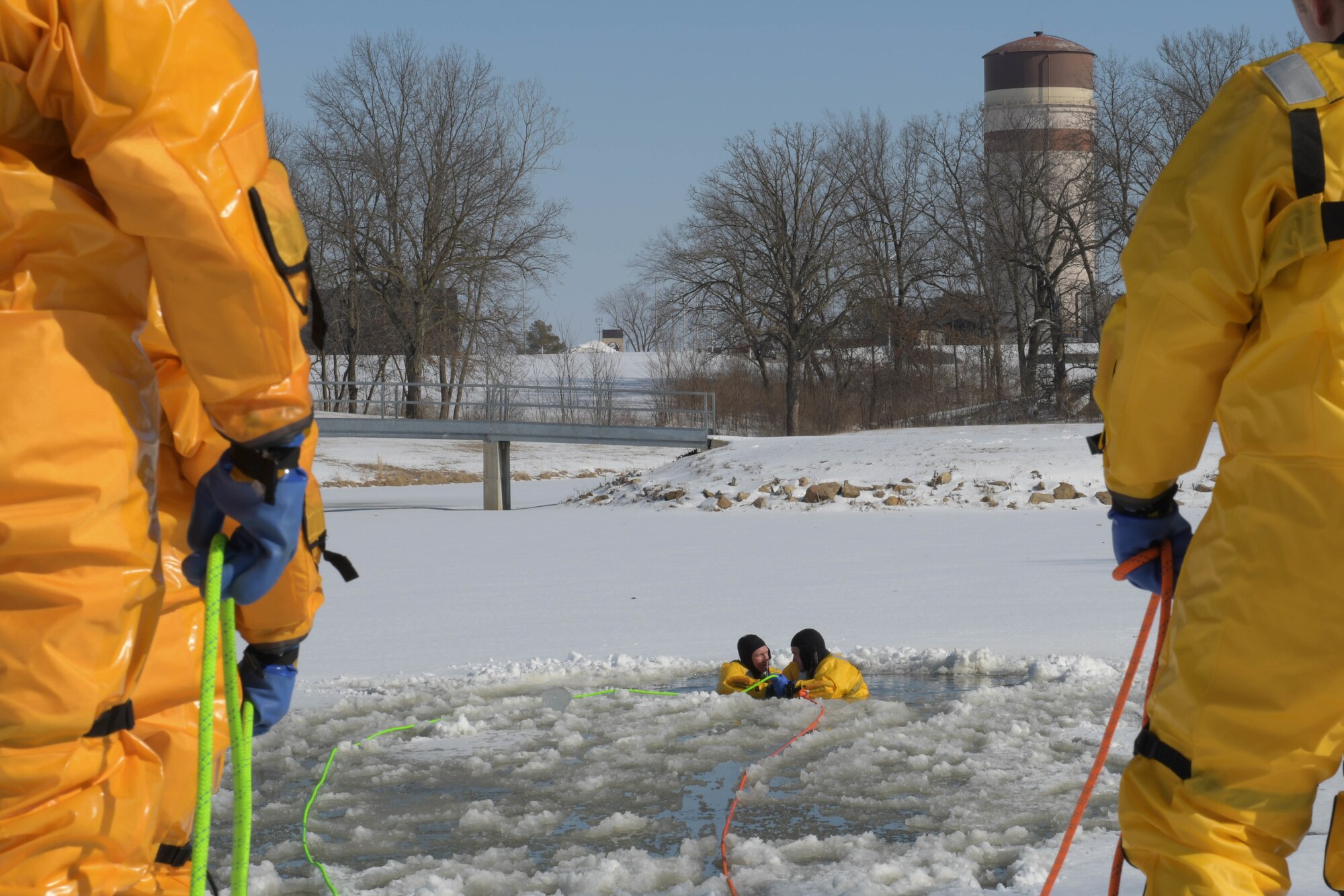 Two firefighters float in the lake in preparation to be pulled out during cold water rescue training.