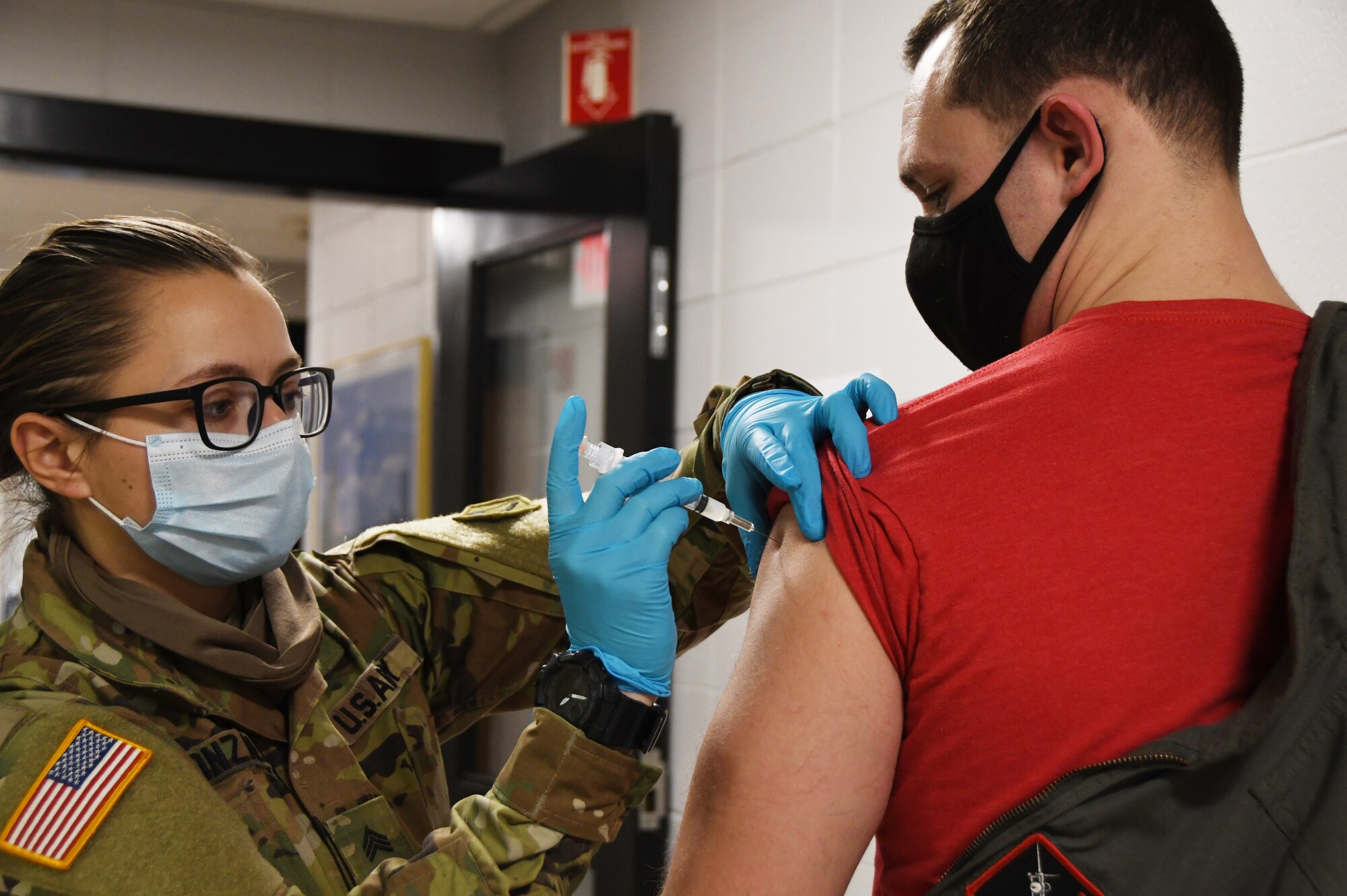 U.S. Army Sgt. Selena Gonzalez, a combat medic with the Massachusetts Army National Guard Medical Command, administers a vaccine to Air Force Capt. Alexander ‘Rhino’ Nielsen, a pilot with the 131st Fighter Squadron, at the base clinic Feb. 5, 2021. Barnestormers have been stepping up to fight the COVID-19 pandemic by volunteering to get vaccinated. (U.S. Air National Guard photo by Staff Sgt. Hanna Smith)