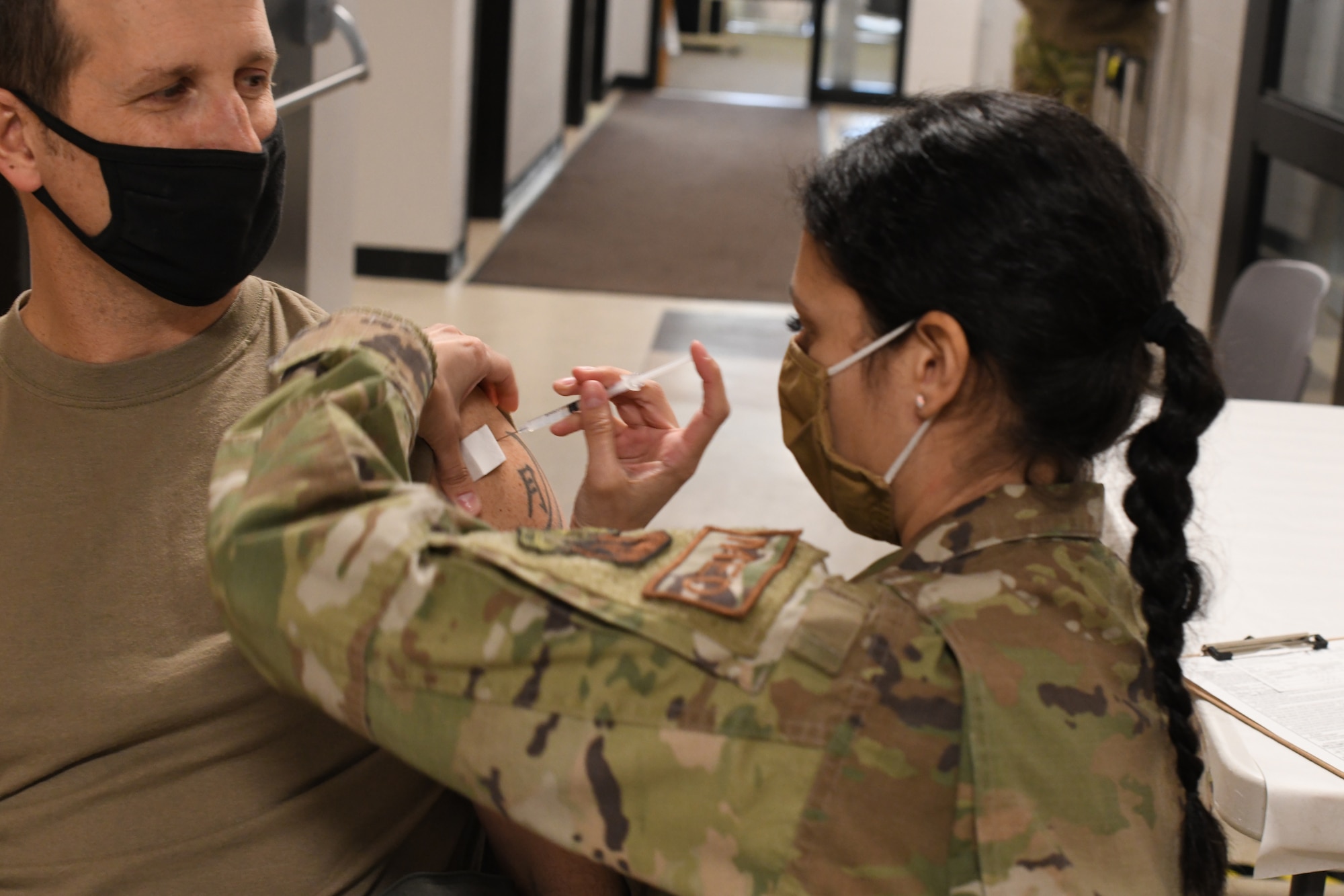 U.S. Air Force Col. David ‘Moon’ Halasi-Kun, vice-commander, 104th Fighter Wing, receives his COVID-19 vaccination from Staff Sgt. Daniela Rizzari, aeromedical technician, 104th Medical Group, at the base clinic on Feb. 23, 2021. Barnestormers have been stepping up to fight the COVID-19 pandemic by volunteering to get vaccinated. (U.S. Air National Guard photo by Staff Sgt. Hanna Smith)