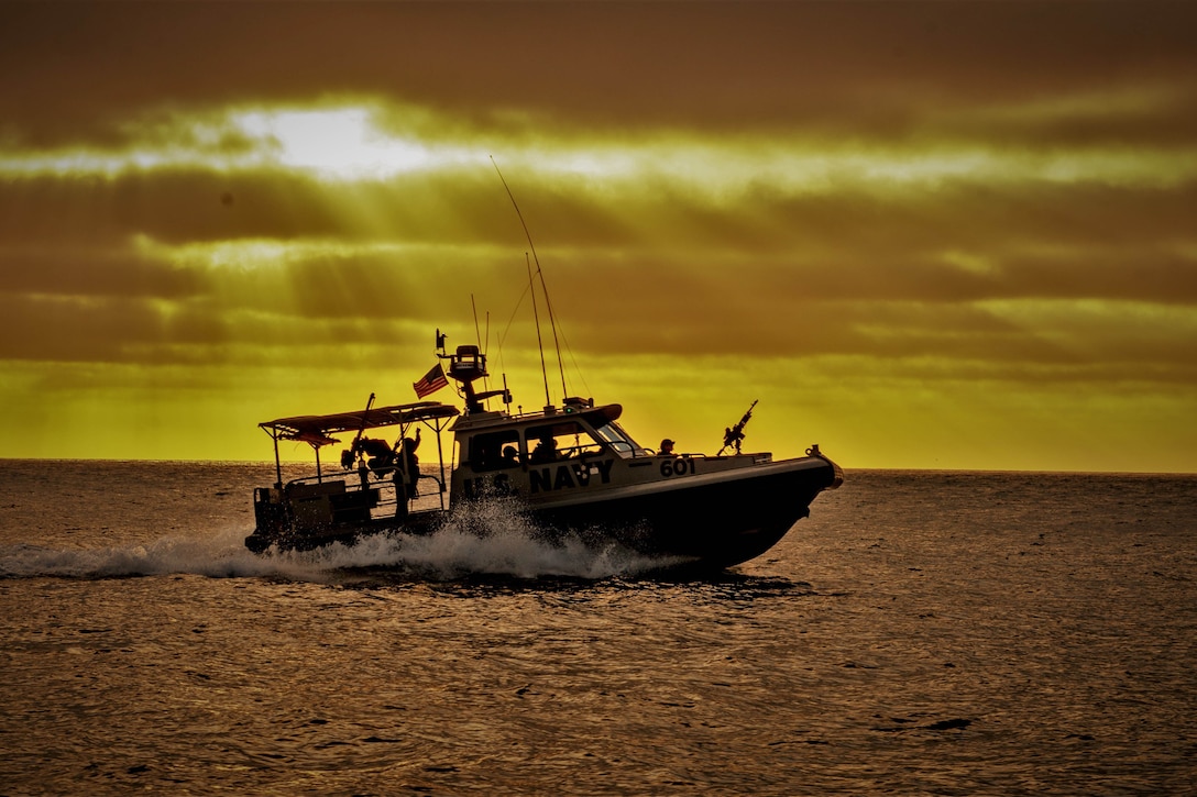 Sailors transit the sea in a boat under a sunlit sky.