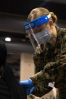 U.S. Navy Hospitalman Tatum Becker, a Hillsboro, Oregon, native with Combat Logistics Battalion 22 (CLB-22), administers a COVID-19 vaccine to a local Philadelphia resident during the opening of the state-run, federally-supported Center City Community Vaccination Center at the Pennsylvania Convention Center in Philadelphia, March 3, 2021.
