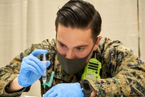 U.S. Navy Hospital Corpsman 2nd Class Orbie VanCurine, a native of Mansfield, Texas, with Combat Logistics Battalion 22 (CLB-22), prepares a COVID-19 vaccine during the opening of the state-run, federally-supported Center City Community Vaccination Center at the Pennsylvania Convention Center in Philadelphia on March 3, 2021.