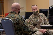 U.S. Marine Corps Lt. Col. James D. Thornburg Jr., left, commanding officer of Combat Logistics Battalion 22 (CLB-22), and U.S. Army Brig. Gen. Robert E. Suter, right, deputy surgeon with U.S. Army North, discuss vaccination operations during the opening of the state-run, federally-supported Center City Community Vaccination Center at the Pennsylvania Convention Center in Philadelphia on March 3, 2021.