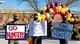 three military members hold different and colorful signs that read, "Thank you," "Thank you for all you do," and "Thank you Hunters."