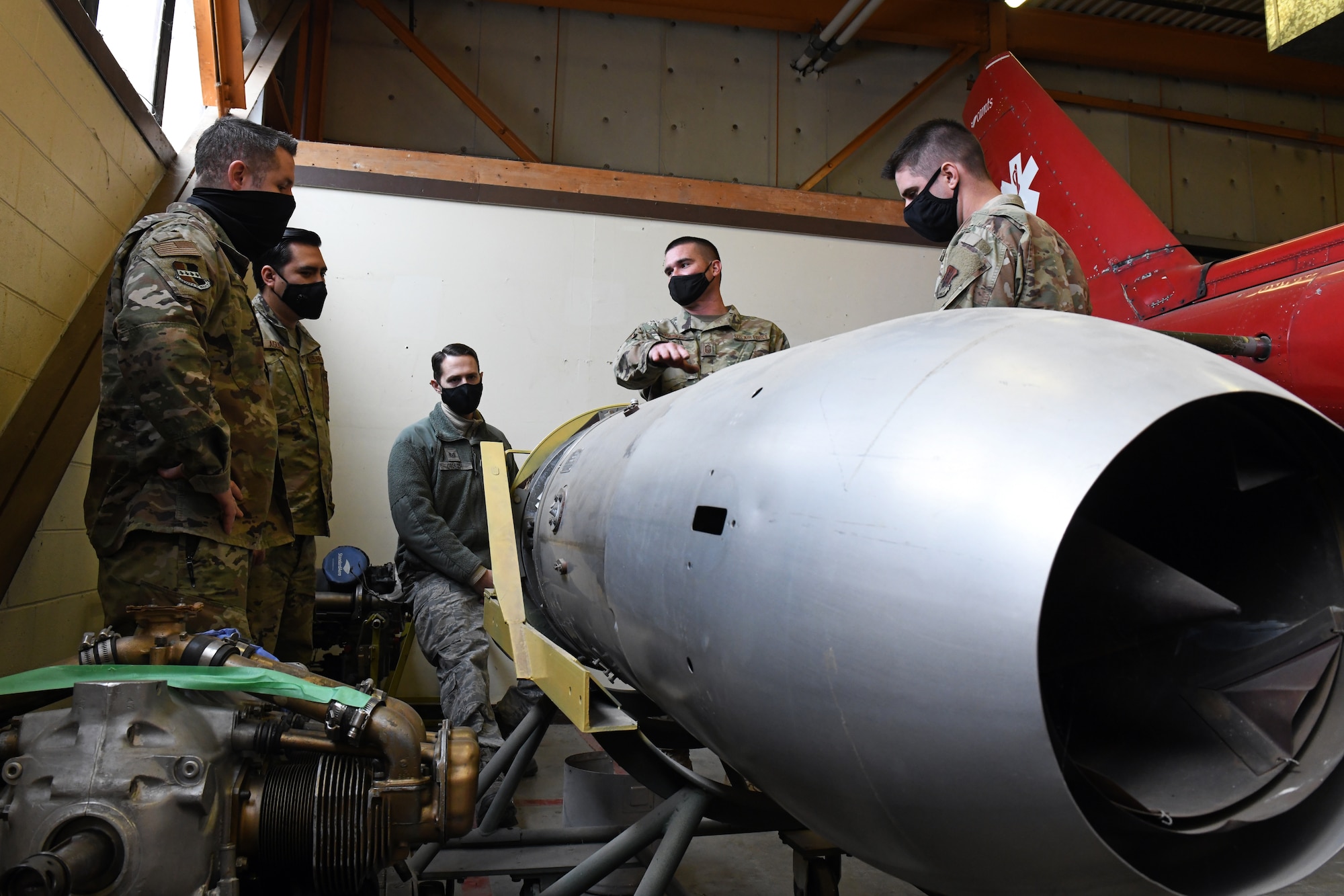 Senior Master Sgt. Matthew Parker, 349th Maintenance Group quality assurance superintendent, center right, talks with Airmen assigned to Beale Air Force Base about the Fairchild J44 turbojet, Feb. 16, 2021, at Travis Air Force Base, California. The Airmen visited Travis to learn about the various components on different types of aircraft. (U.S. Air Force photo by Airman 1st Class Luis A. Ruiz-Vazquez)