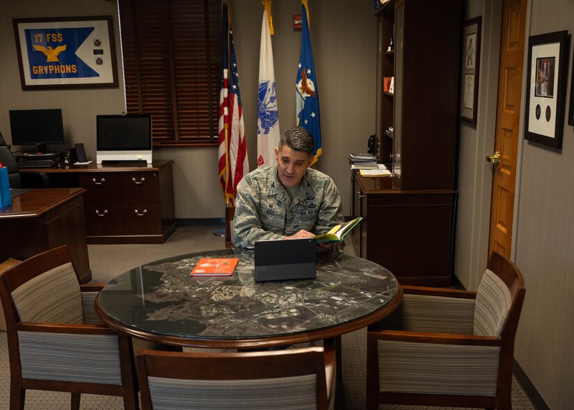 An Airman reads to students via video chat.