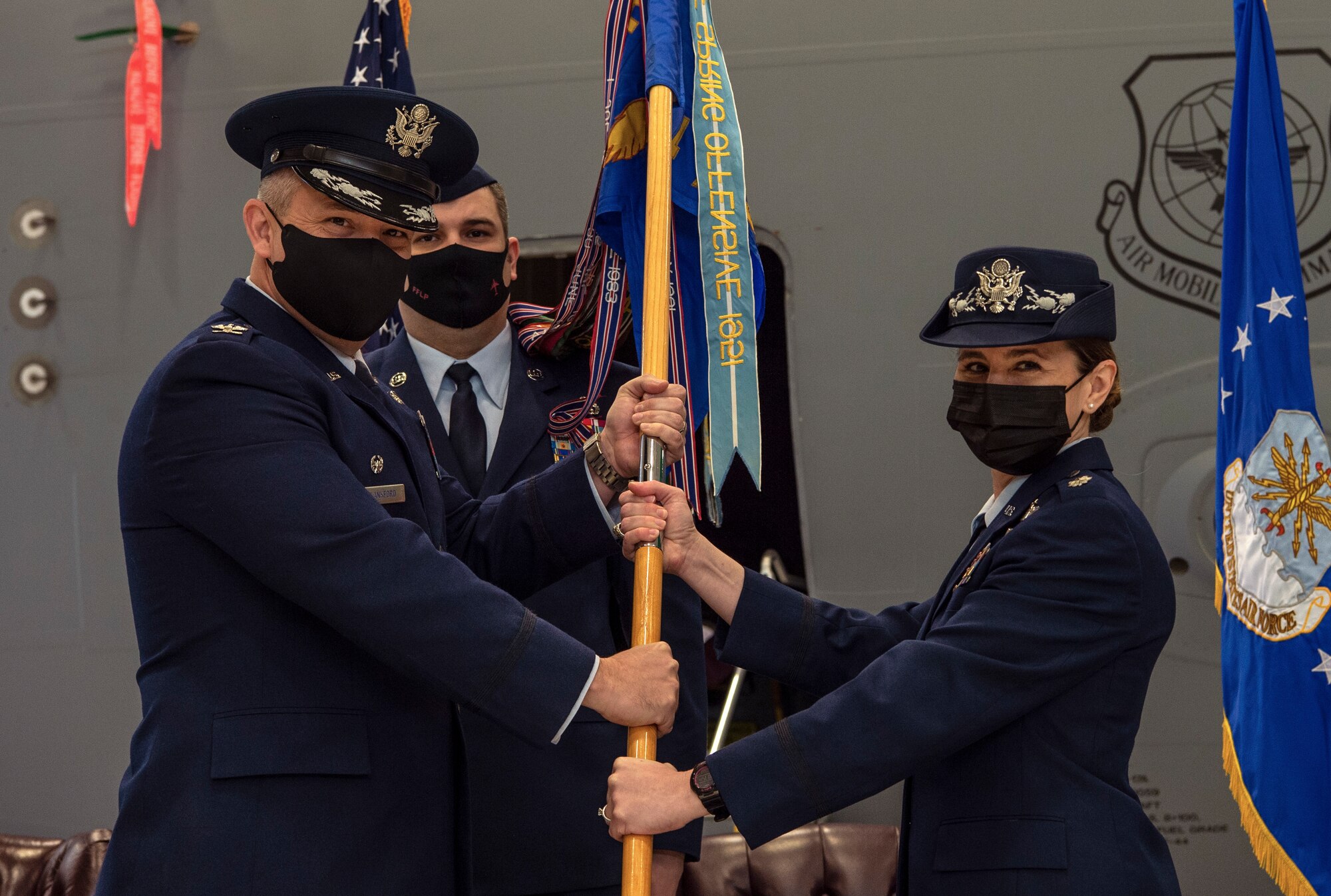 U.S. Air Force Col. Robert Lankford, left, 62nd Operations Group commander, presents the 4th Airlift Squadron guidon to U.S. Air Force Lt. Col. Ellen Canup, incoming 4th AS commander, during a change of command ceremony at Joint Base Lewis-McChord, Washington, March 4, 2021. Canup is the 56th commander to lead the 4th AS, the oldest active airlift squadron in the Air Force, which was activated in 1935. (U.S. Air Force photo by Senior Airman Tryphena Mayhugh)