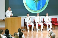 Capt. Charles (left) speaks to the audience during the Kennedy ceremony. Also picture d are ONI Commander Rear Adm. Price and Rear Adm. Okon