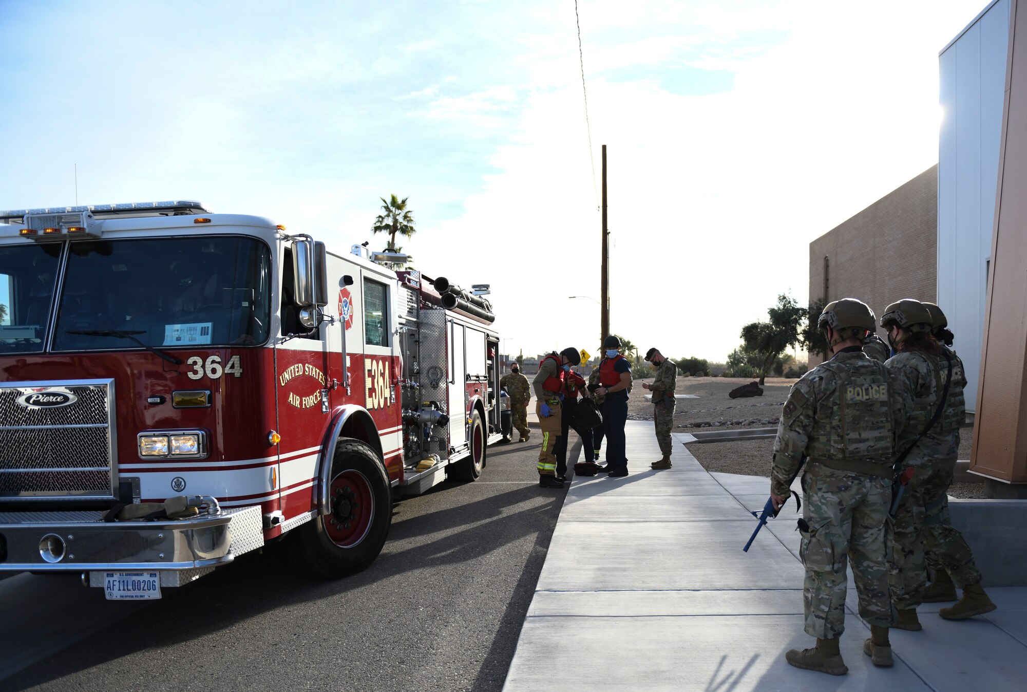 Airmen from the 56th Security Forces Squadron and the 56th Civil Engineer Squadron arrive on the scene of an active shooter exercise Feb. 26, 2021, at Luke Air Force Base, Arizona. Security forces escorted the firefighters into the area in play during the exercise, which evaluated the training, readiness and capability of Luke Airmen to respond to an active shooter. Exercises ensure Airmen meet warfighting needs with a continuous drive toward more effective and efficient training. (U.S. Air Force photo by Staff Sgt. Amber Carter)