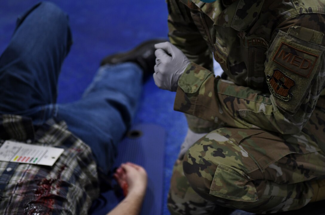 An Airman from the 56th Operational Medical Readiness Squadron provides medical care to a simulated victim during an active shooter exercise Feb. 26, 2021, at Luke Air Force Base, Arizona. Exercise evaluators assessed the training, readiness and capability of Luke Airmen to respond to an active shooter threat on the installation. Exercises ensure Airmen meet warfighting needs with a continuous drive toward more effective and efficient training. (U.S. Air Force photo by Staff Sgt. Amber Carter)