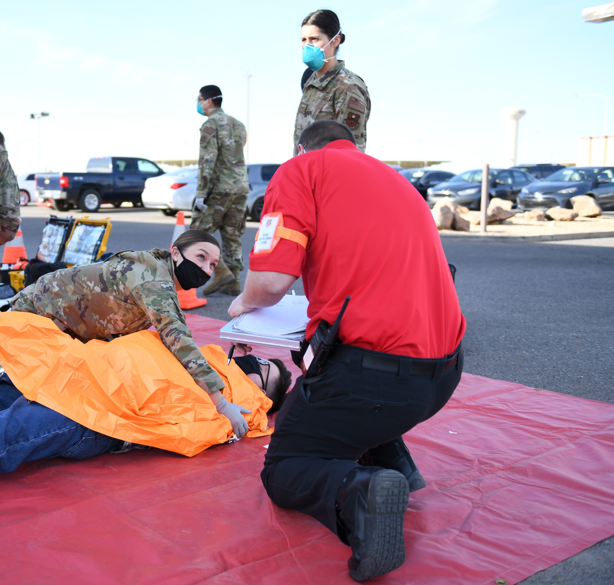 Senior Airman Kayci Serino, 56th Operational Medical Readiness Squadron medical technician, provides medical care to a simulated victim during an active shooter exercise Feb. 26, 2021, at Luke Air Force Base, Arizona. Exercise evaluators from the inspector general office assessed medics on the care they provided to each simulated victim during the exercise. Exercises ensure Airmen meet warfighting needs with a continuous drive toward more effective and efficient training. (U.S. Air Force photo by Staff Sgt. Amber Carter)
