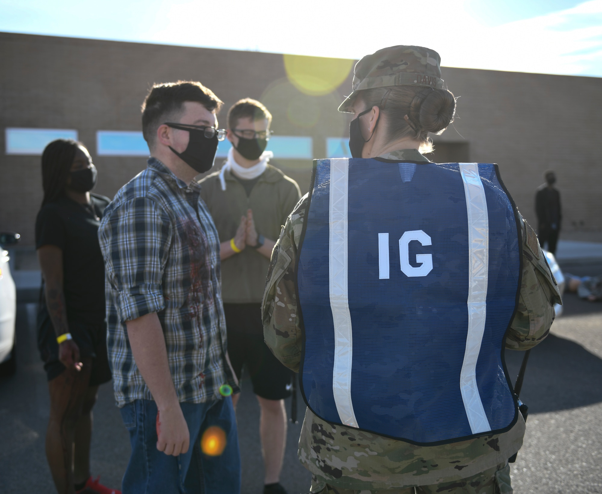 Master Sgt. Kelly Davis, 56th Fighter Wing inspector general, gathers information from the simulated victims to further analyze and assess the first responders during an active shooter exercise Feb. 26, 2021, at Luke Air Force Base, Arizona. Wing IG office is responsible for ensuring training requirements are met and Luke Airmen are combat-ready through evaluations and reports based on the training, readiness and capability of Luke Airmen. Exercises ensure Airmen meet warfighting needs with a continuous drive toward more effective and efficient training. (U.S. Air Force photo by Staff Sgt. Amber Carter)