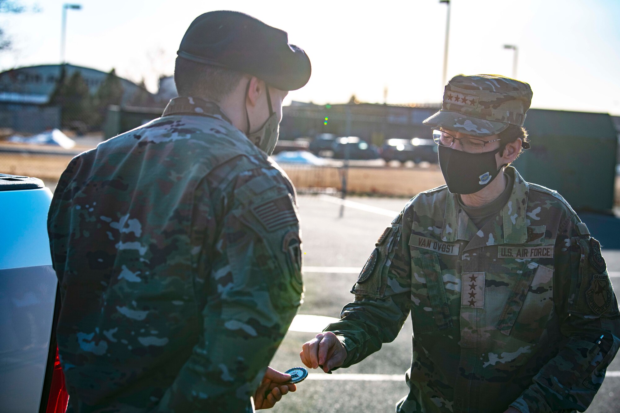 U.S. Air Force Gen. Jacqueline Van Ovost, Air Mobility Command commander, coins Staff Sgt. Brandon Vance, 92nd Security Forces Squadron installation patrolman, for his innovative contributions to the improvement of the 92nd SFS mission, at Fairchild Air Force Base, Washington, March 4, 2021. The AMC command team witnessed multiple innovation demonstrations from Fairchild Airmen, emphasizing their strides in accomplishing the mission efficiently. (U.S. Air Force photo by Senior Airman Lawrence Sena)