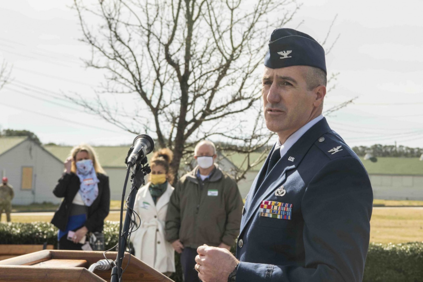A U.S. Air Force colonel speaks to a crowd at the podium