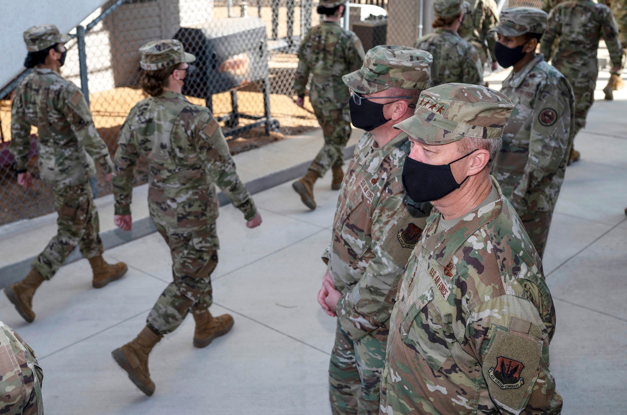 Basic trainees in uniform march in front of leadership.